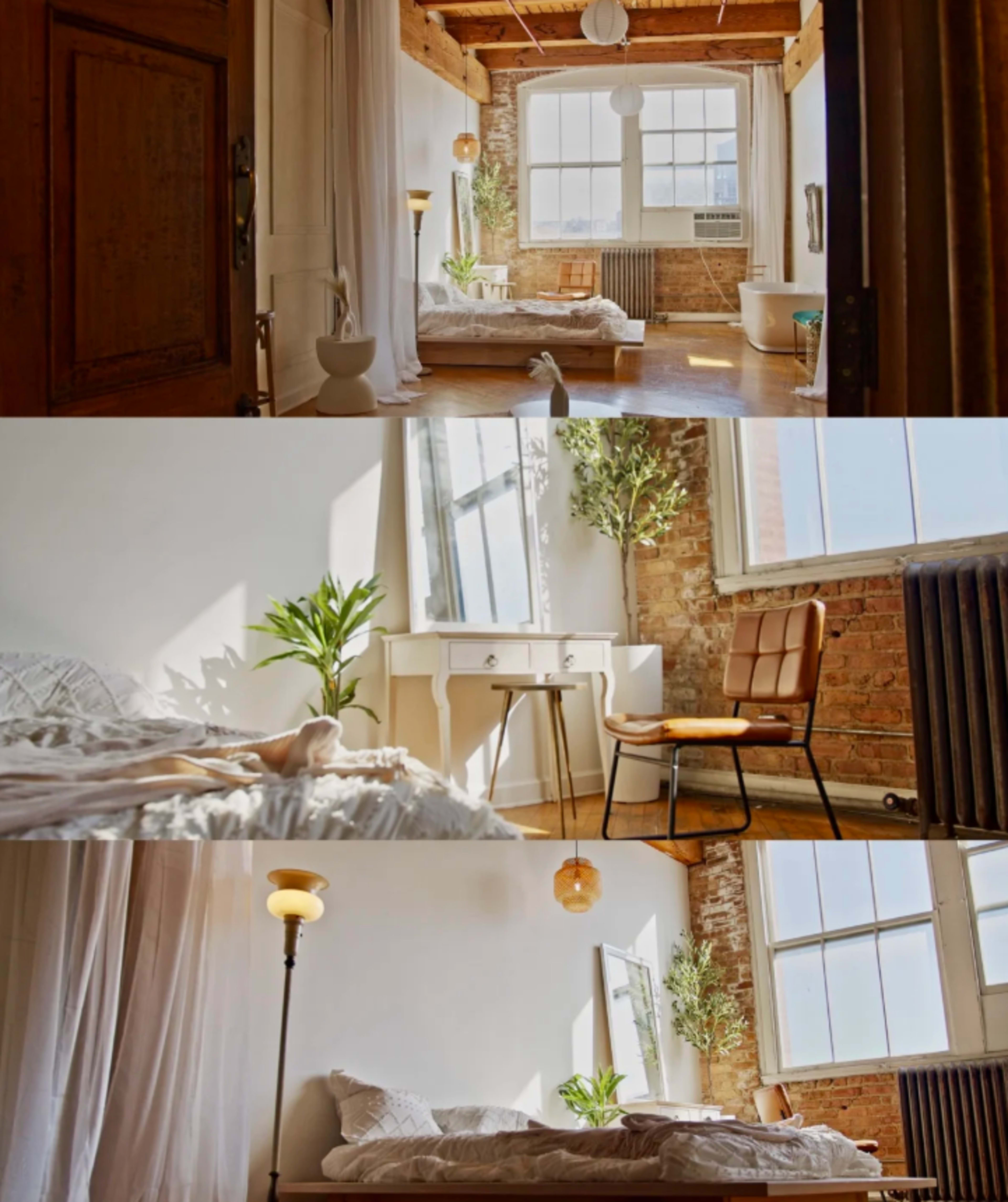 The image shows a bright bedroom featuring a bed, a chair, a vanity table, and large windows with natural light illuminating the space.