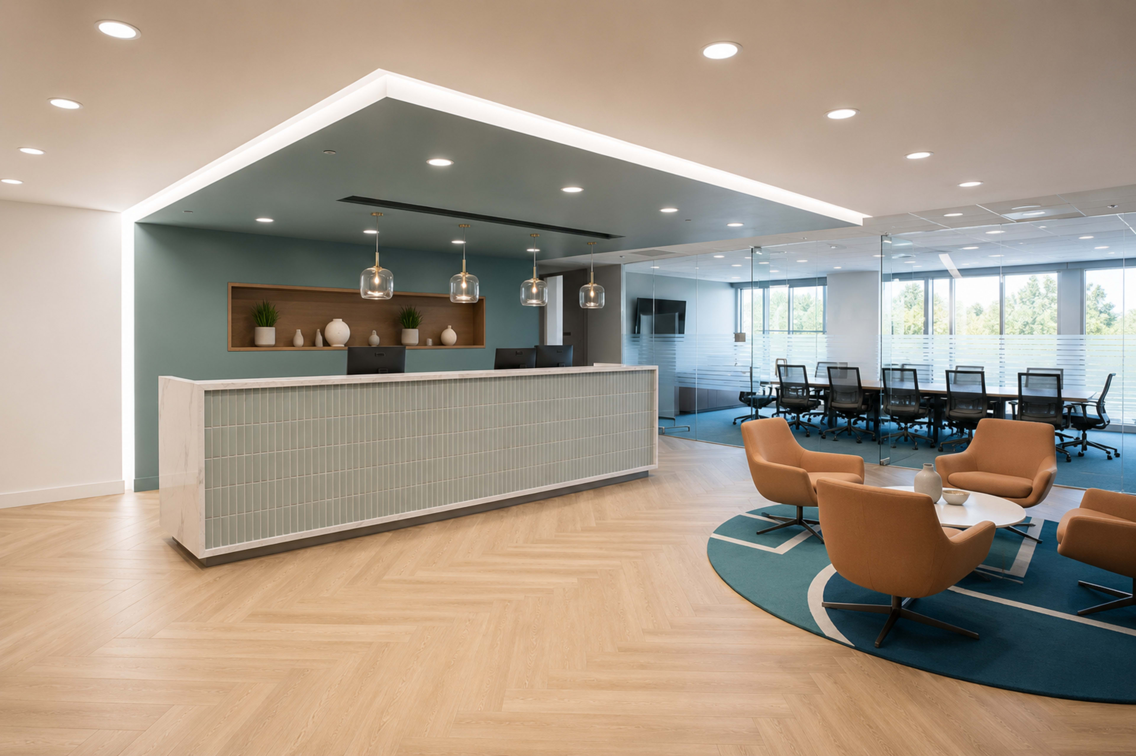 The image shows a modern office reception area with a front desk, seating arrangements, and a conference room in the background.