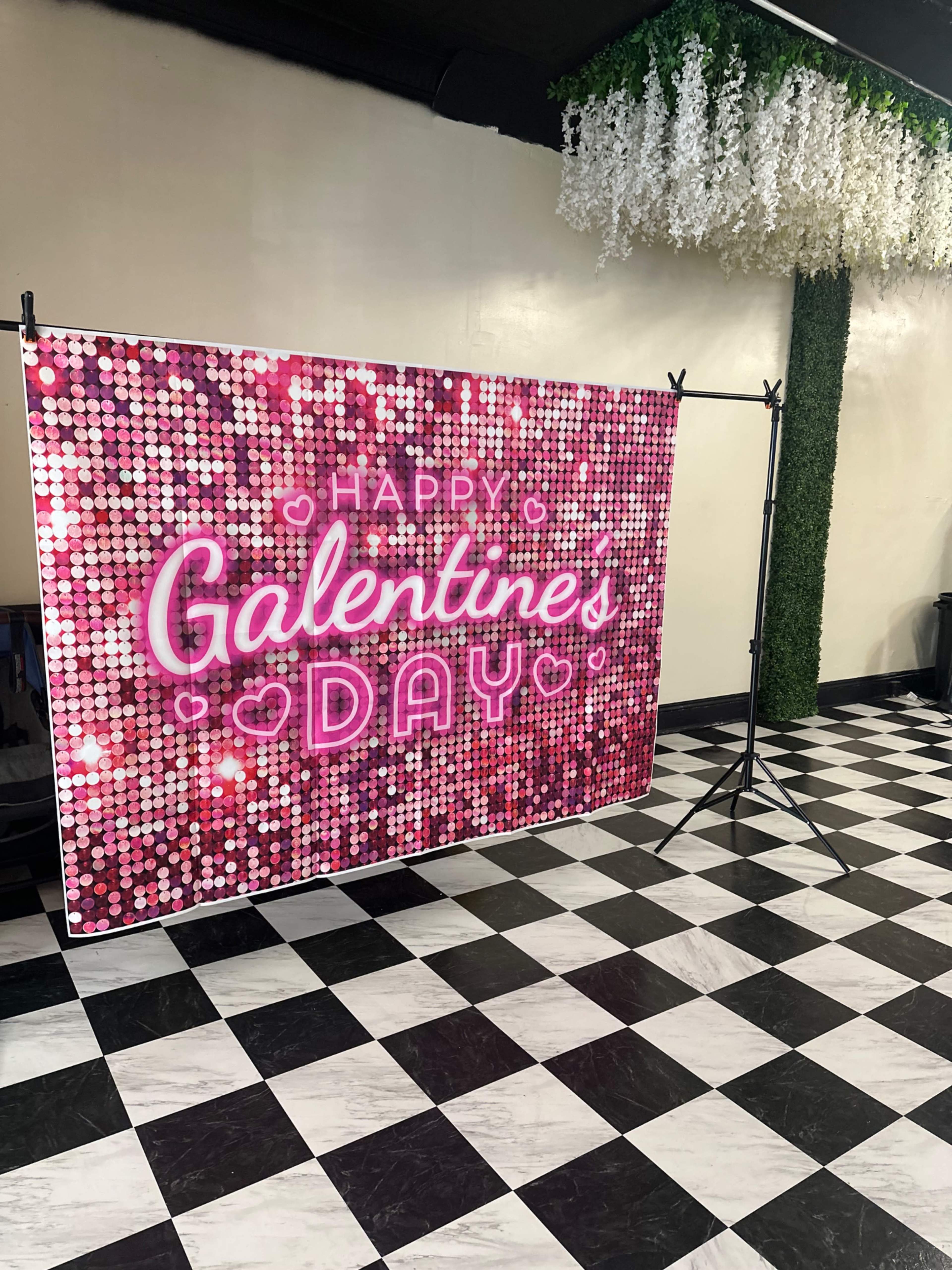 A decorated backdrop for Galentine's Day featuring a pink and white sparkling design with the phrase "Happy Galentine's Day."
