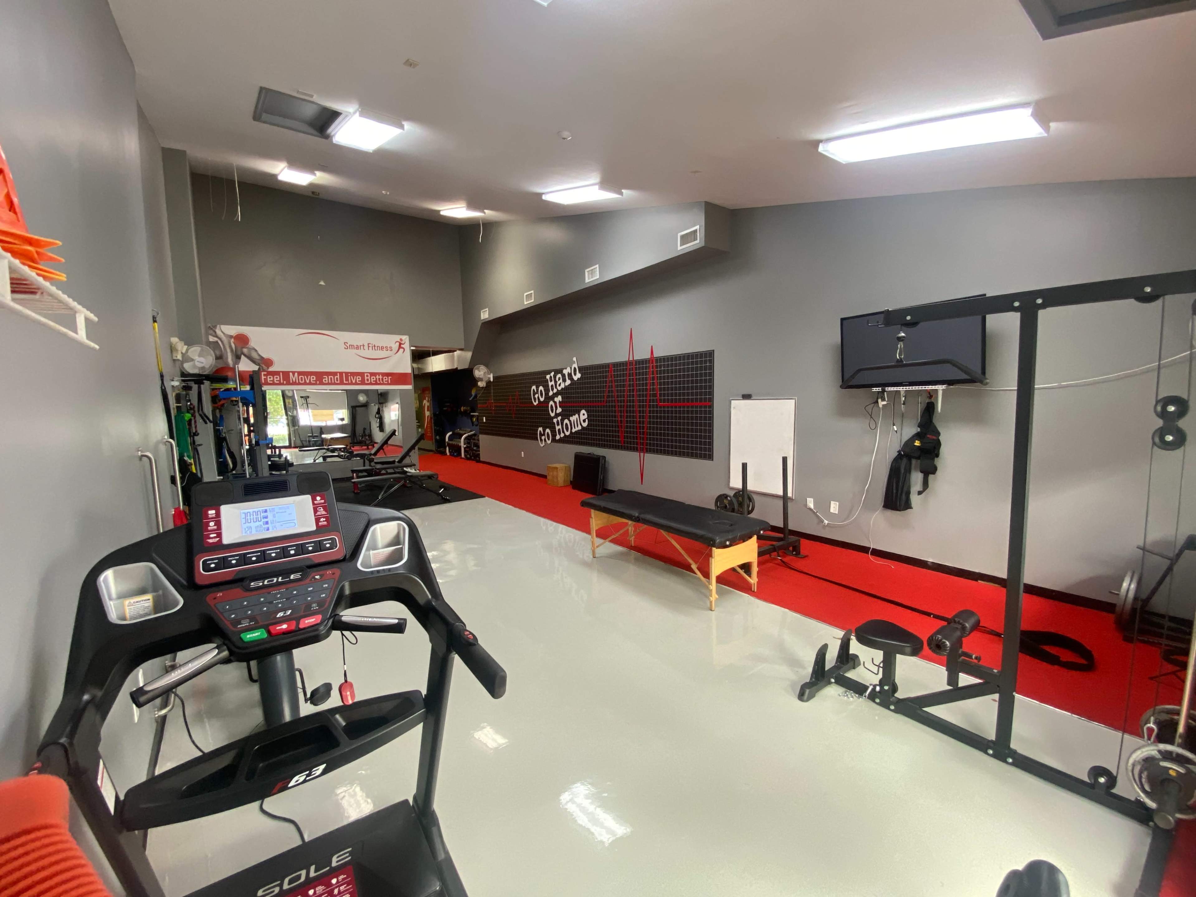 The image shows a fitness facility with exercise equipment, including a treadmill and weight training machines, along with a red and gray color scheme.