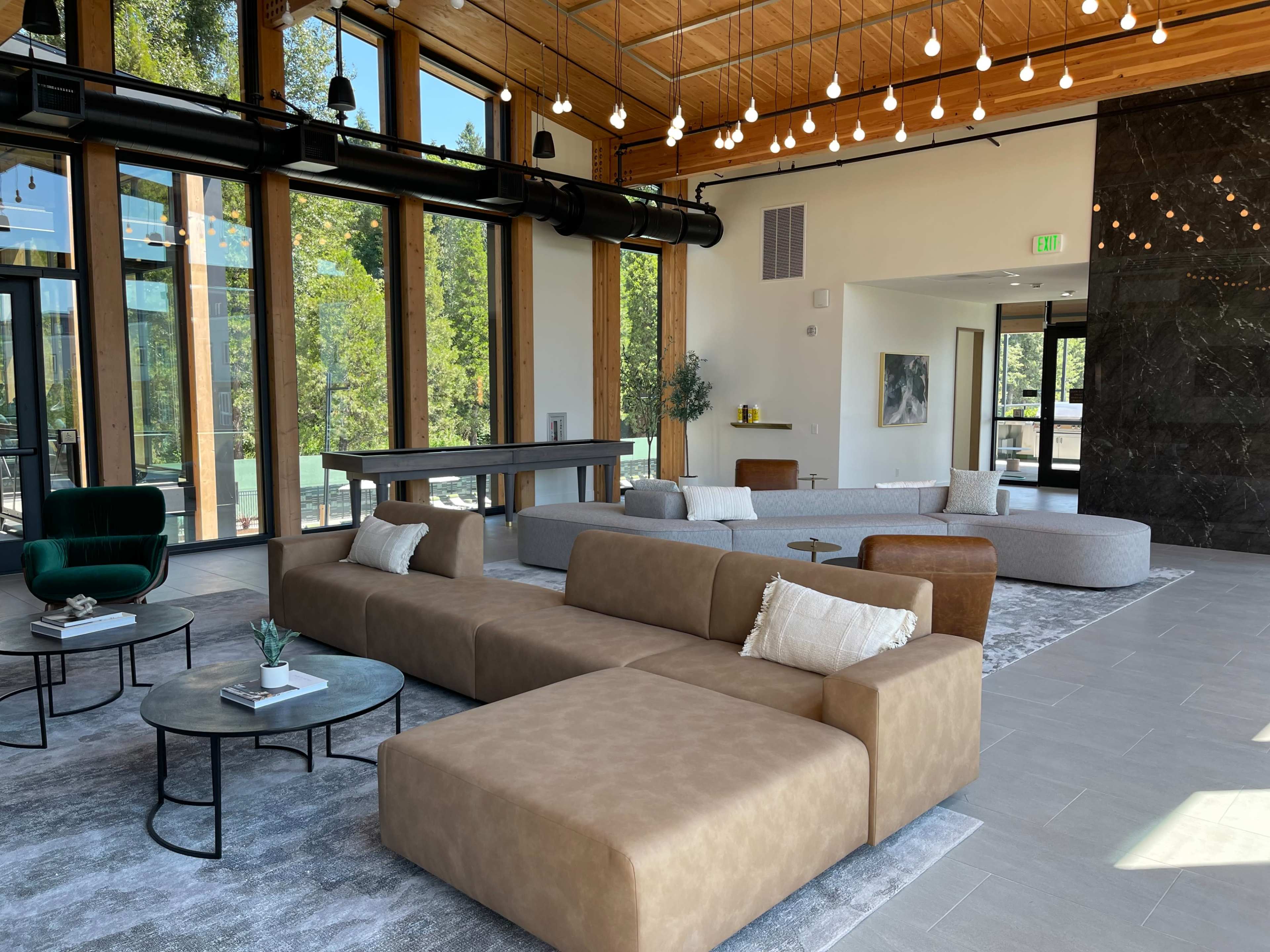 A spacious lounge area featuring modern furniture, large windows, and a sleek design.