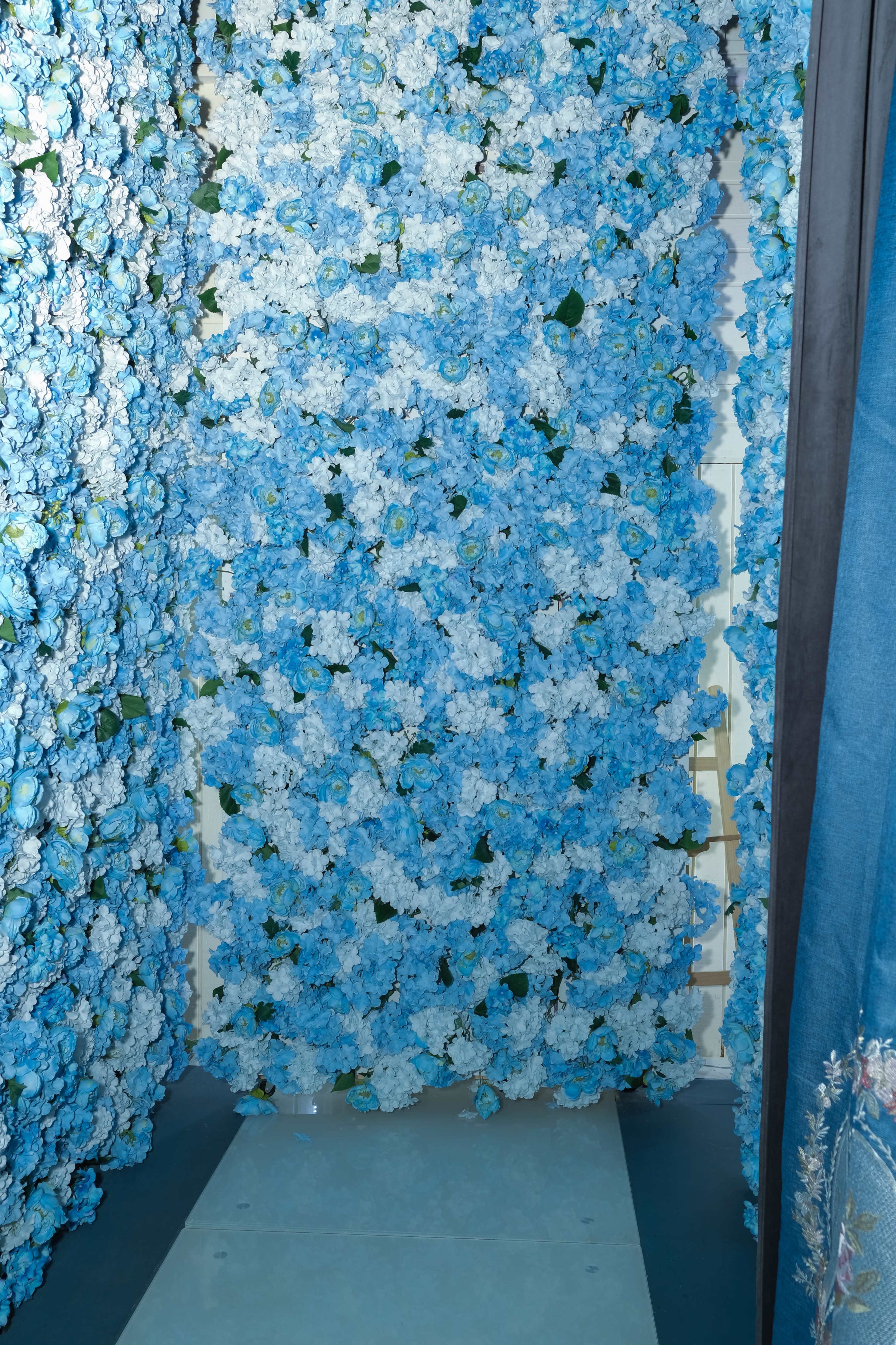 A wall covered with blue and white flowers creates a colorful backdrop in an indoor space.