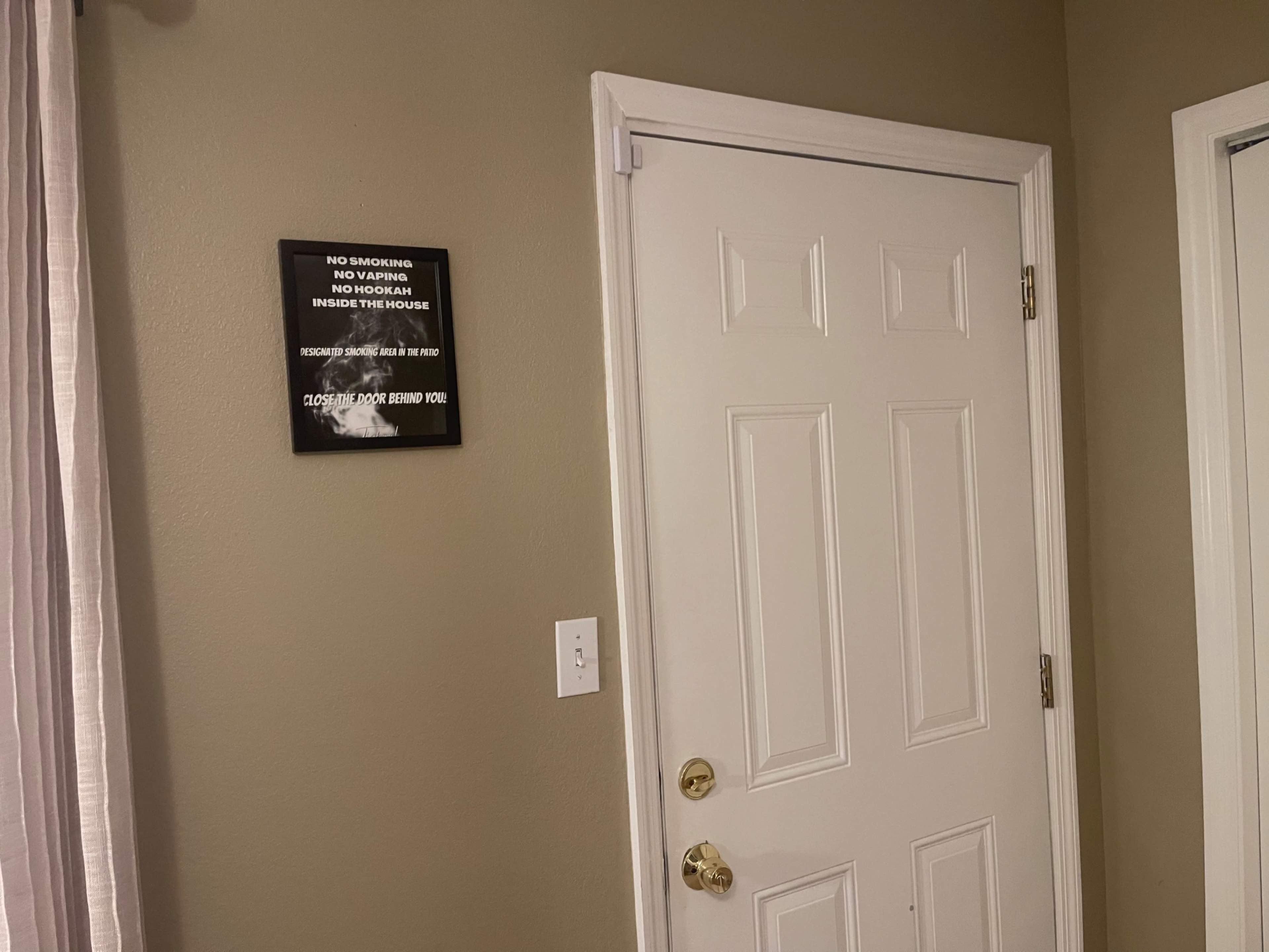A door with a sign mounted on the wall nearby, indicating rules regarding noise and privacy.