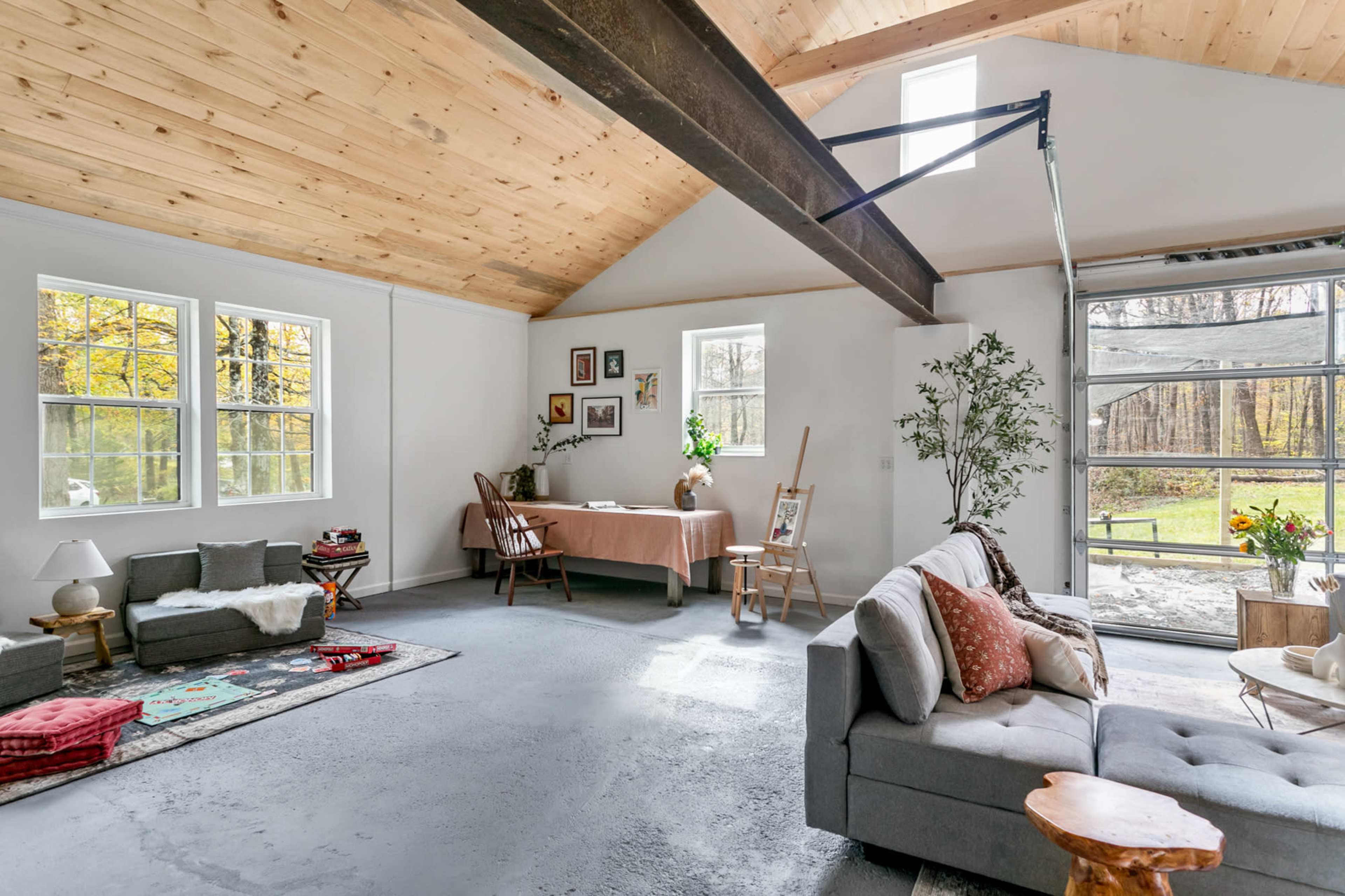 A spacious, modern living area with high ceilings, large windows, and a mix of comfortable seating and decorative elements.
