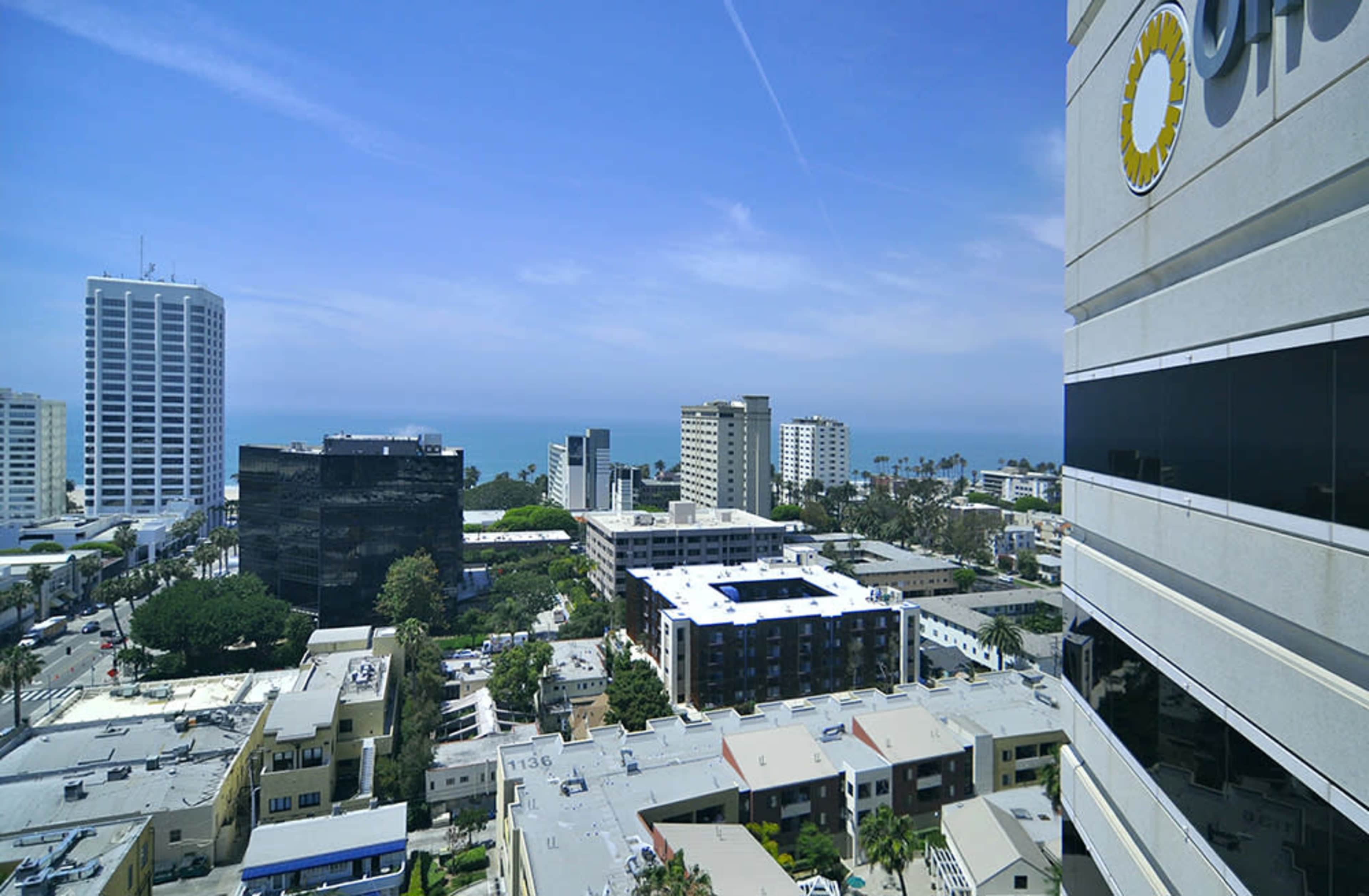A coastal urban landscape with buildings, streets, and the ocean visible in the background.