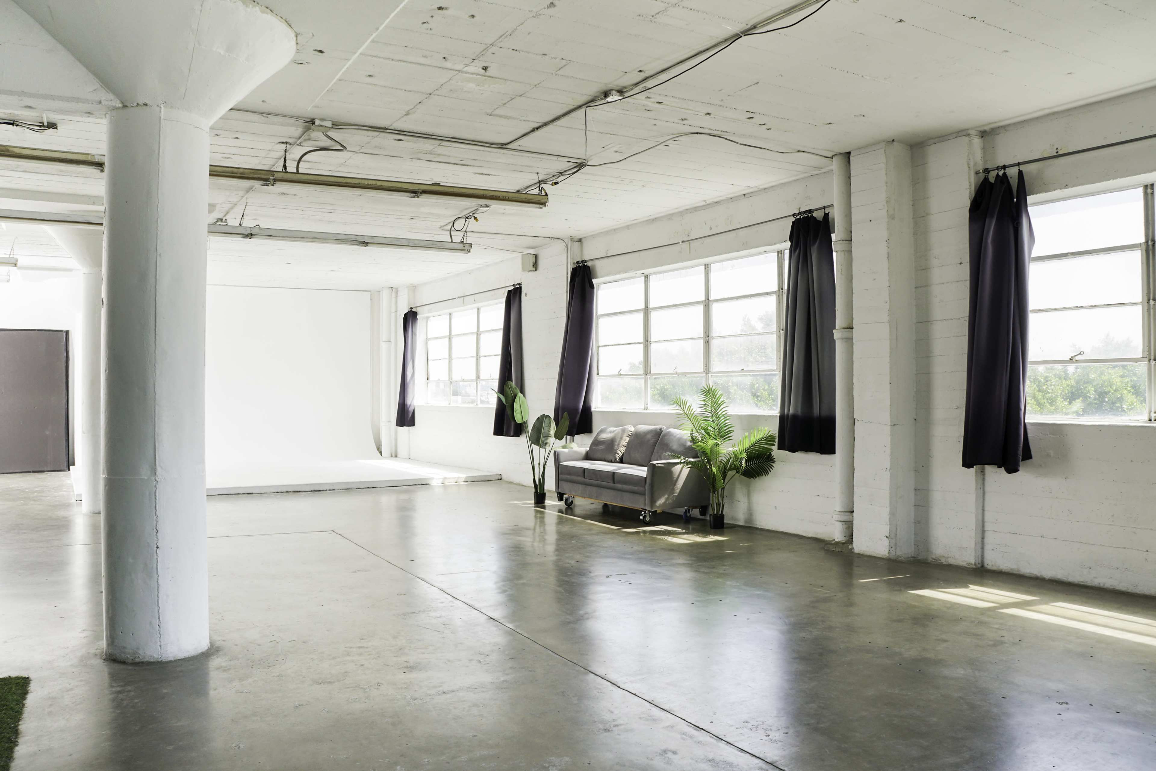 Blackout Loft Studio with central AC, a pre-lit corner cyc wall, Light Tunnel, wooden platform, white wooden reclaimed wall & frameless window with downtown view - PRO II Image in Central LA, Los Angeles, CA