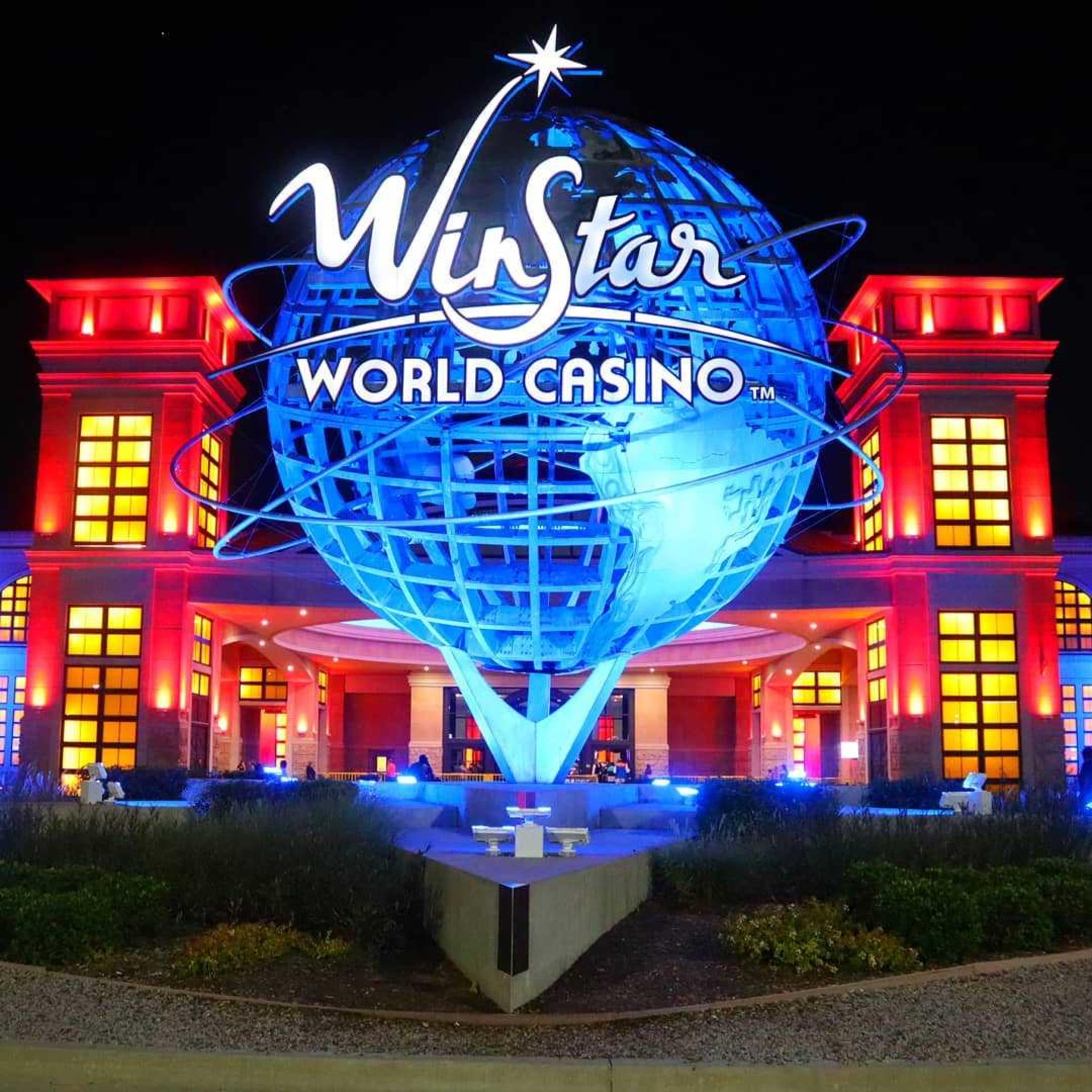The brightly lit entrance of the WinStar World Casino, featuring a large illuminated globe sculpture and red accents on the building.