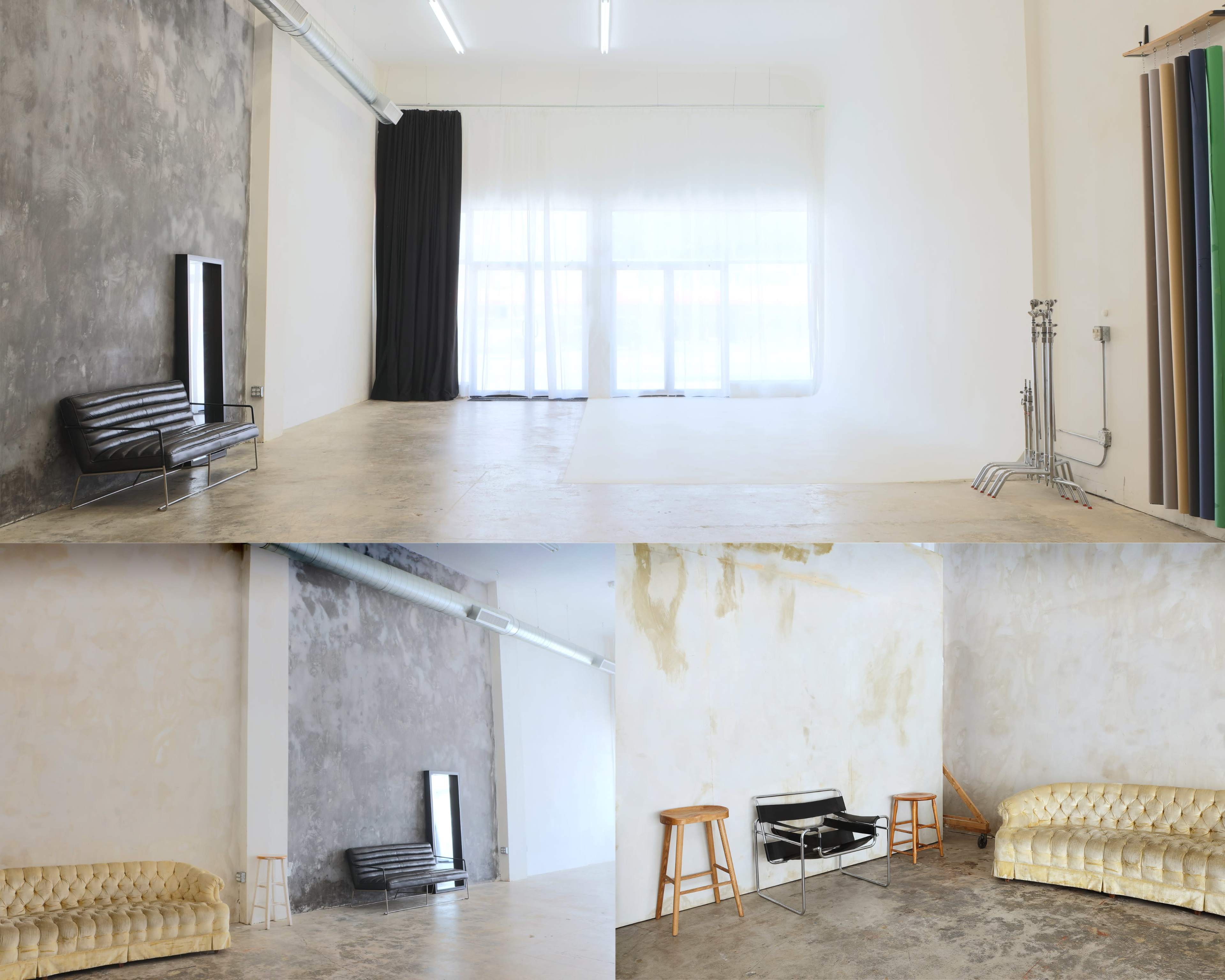 The image shows a spacious photography studio with minimalist furnishings, including a black leather sofa, a mirror, and a couple of stools, set against textured walls in various shades.