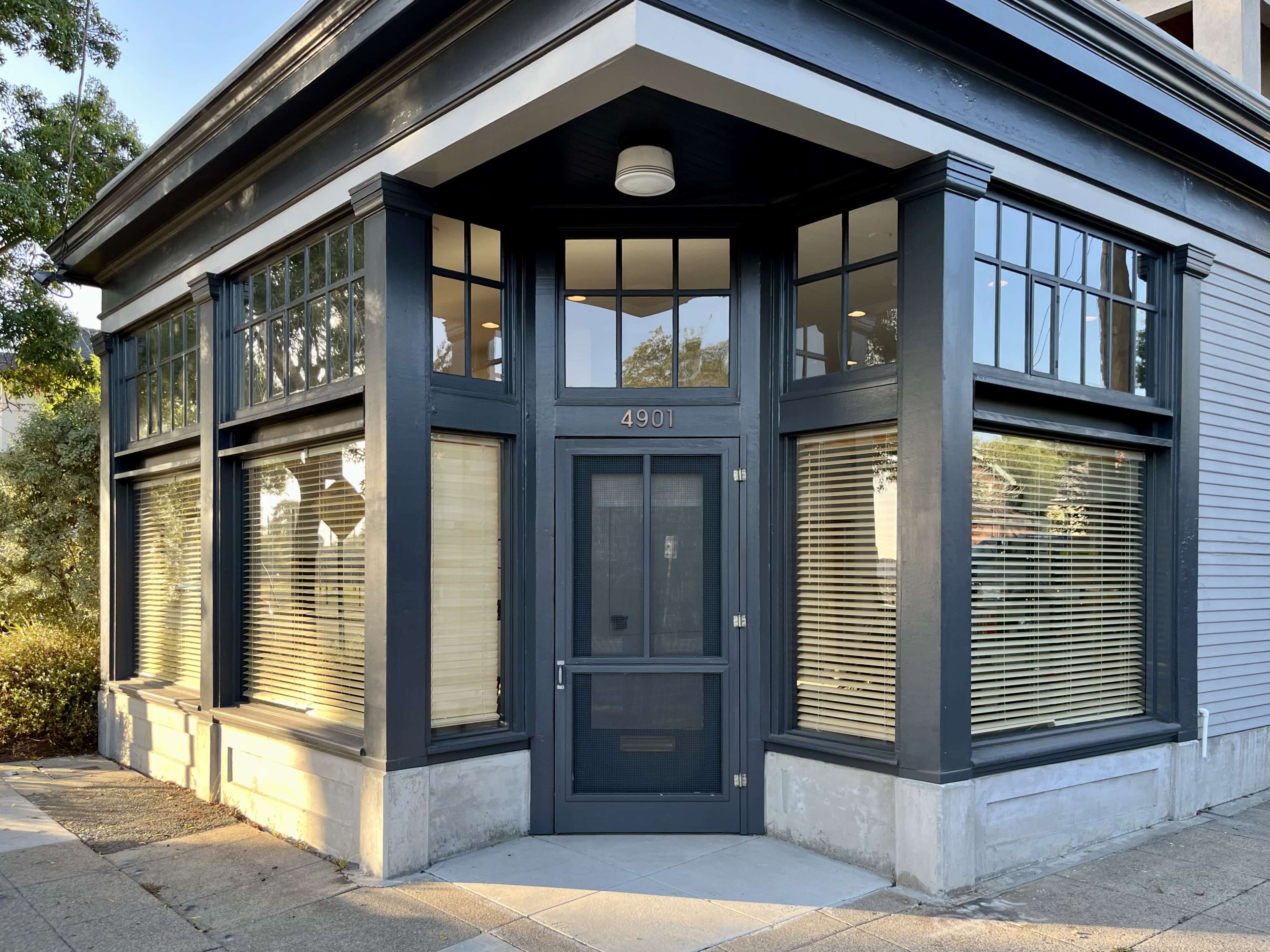 A corner building with large windows and a prominent entrance featuring the number 4901.