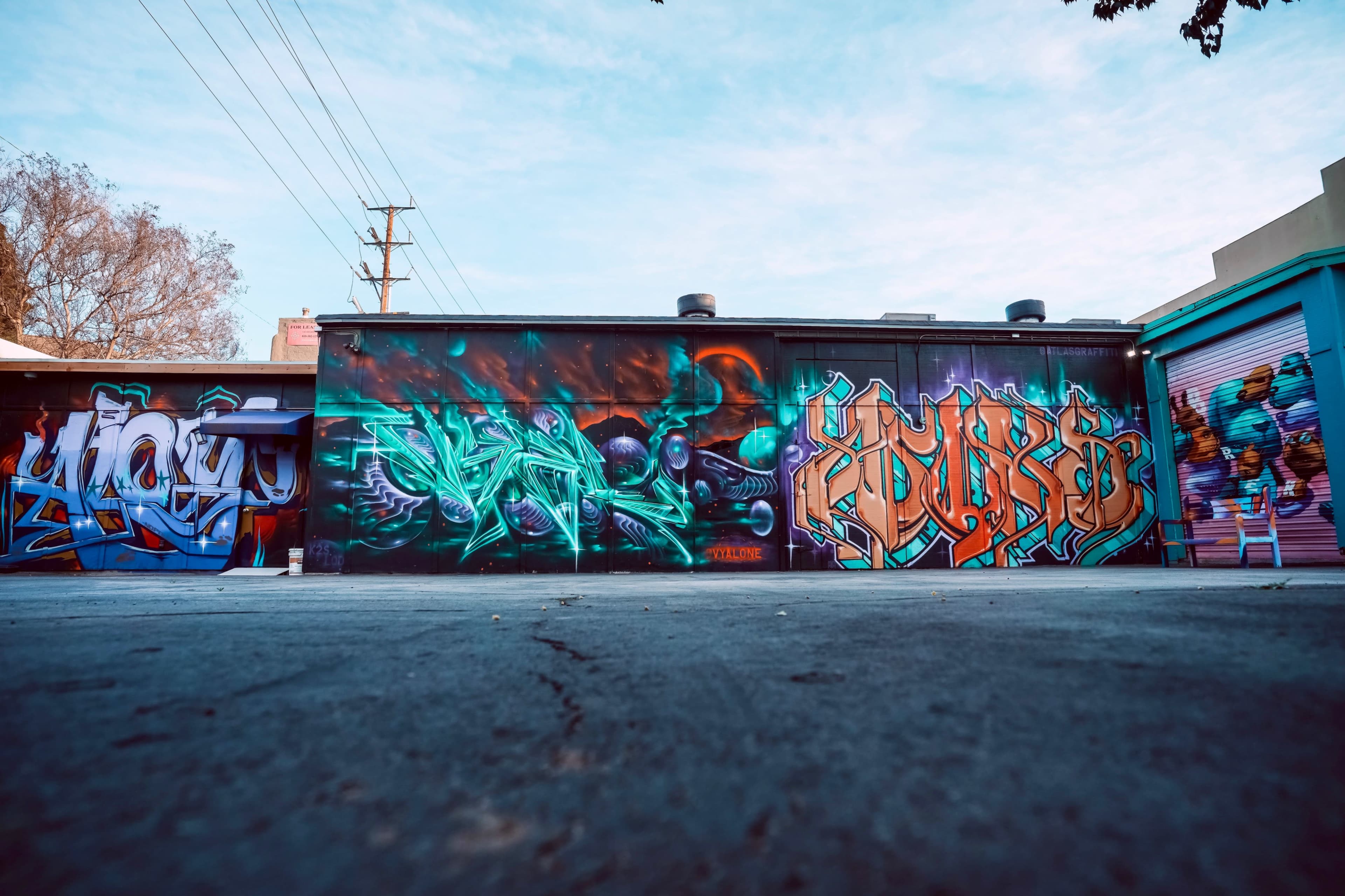 A colorful mural featuring various styles of graffiti art on a building wall.