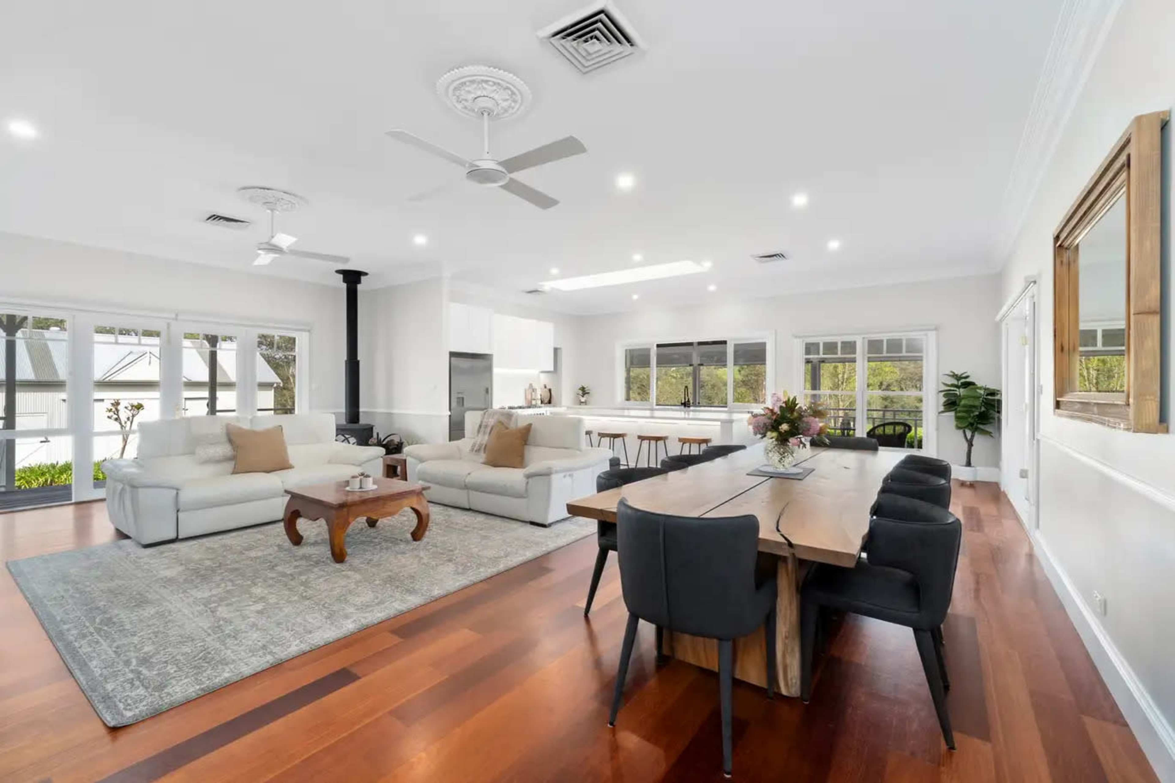 The room features an open layout with a modern living area, a dining table, and large windows allowing natural light to flow in.