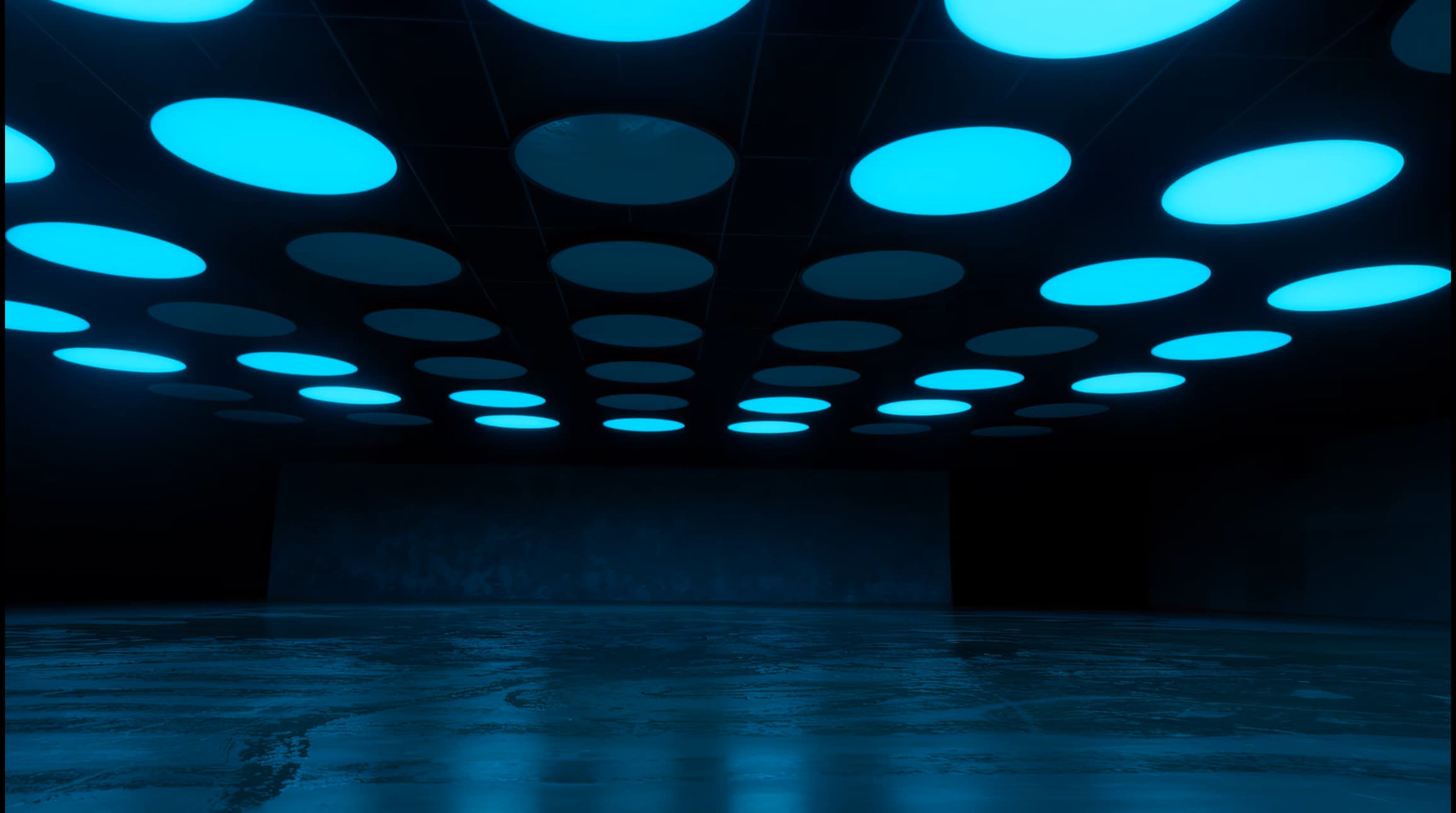 The image shows a dark, modern interior space with a ceiling featuring circular blue lights and a glossy floor reflecting the light.