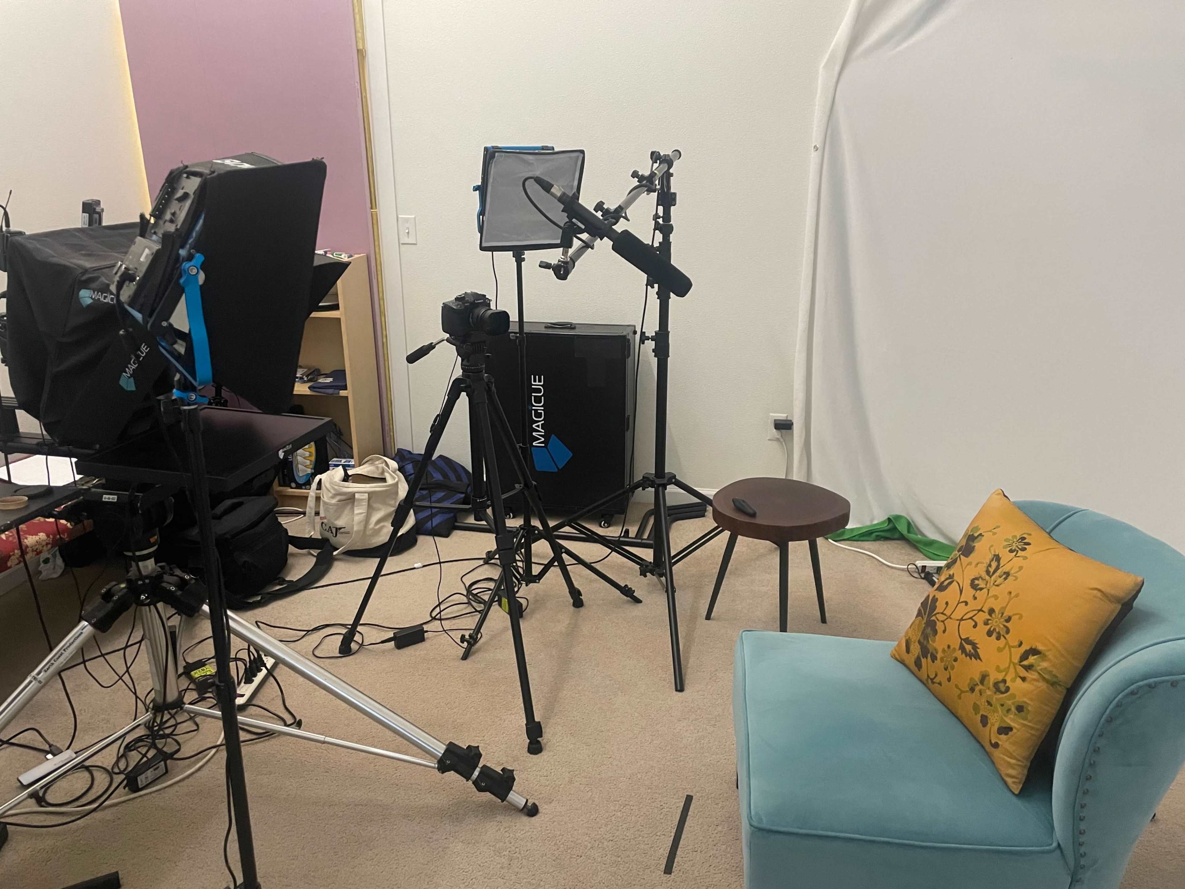 A video recording setup with a chair, camera equipment, and lighting in a studio environment.