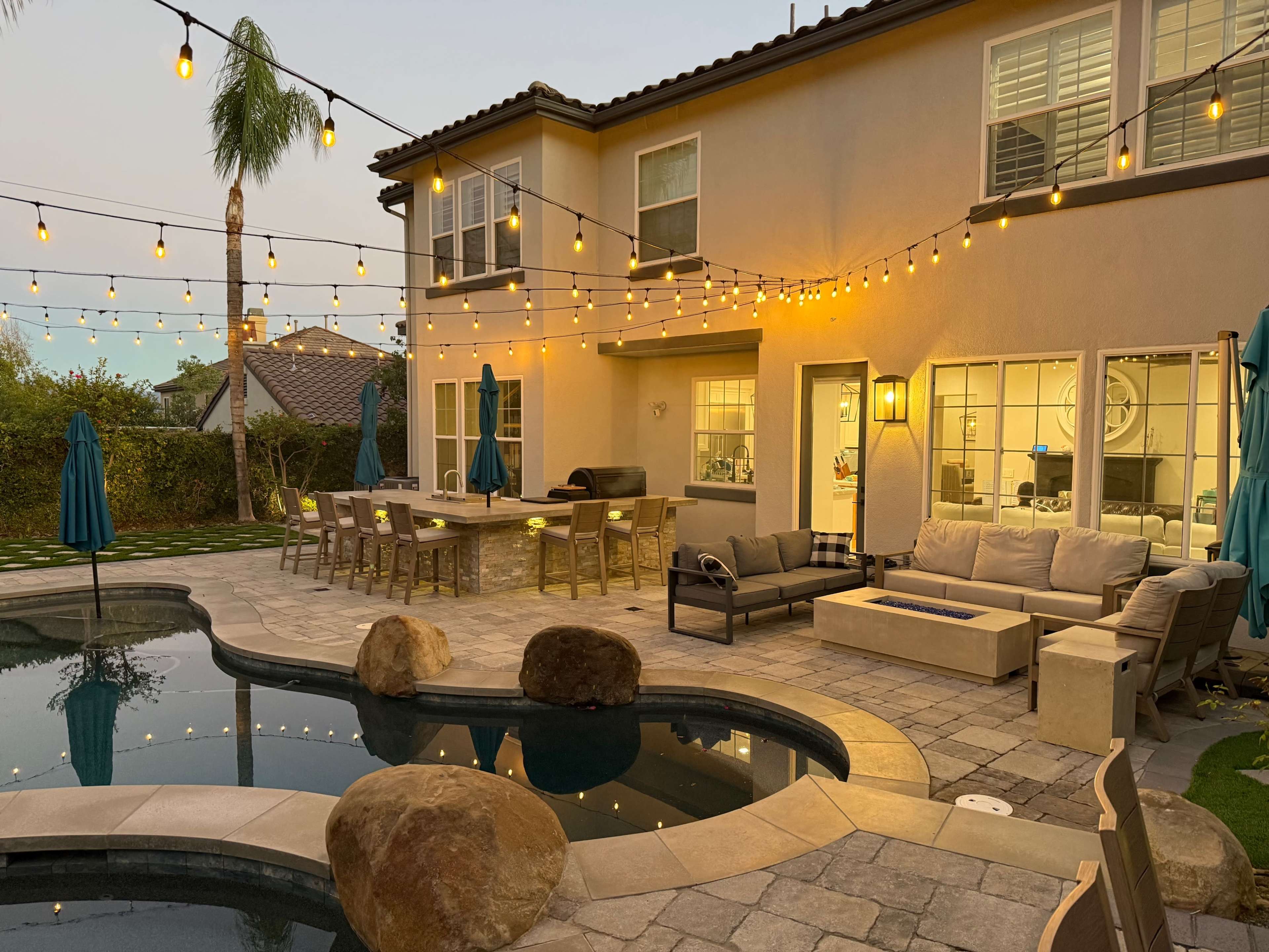 Discover a hidden gem — Surrounded by green hills and palm trees, this tranquil backyard retreat offers a saltwater pool, jacuzzi, and elegant entertaining area. Perfect for celebrations, photoshoots, or relaxing under twinkling string lights. 💦🌴 Image in Stevenson Ranch, Valencia, CA