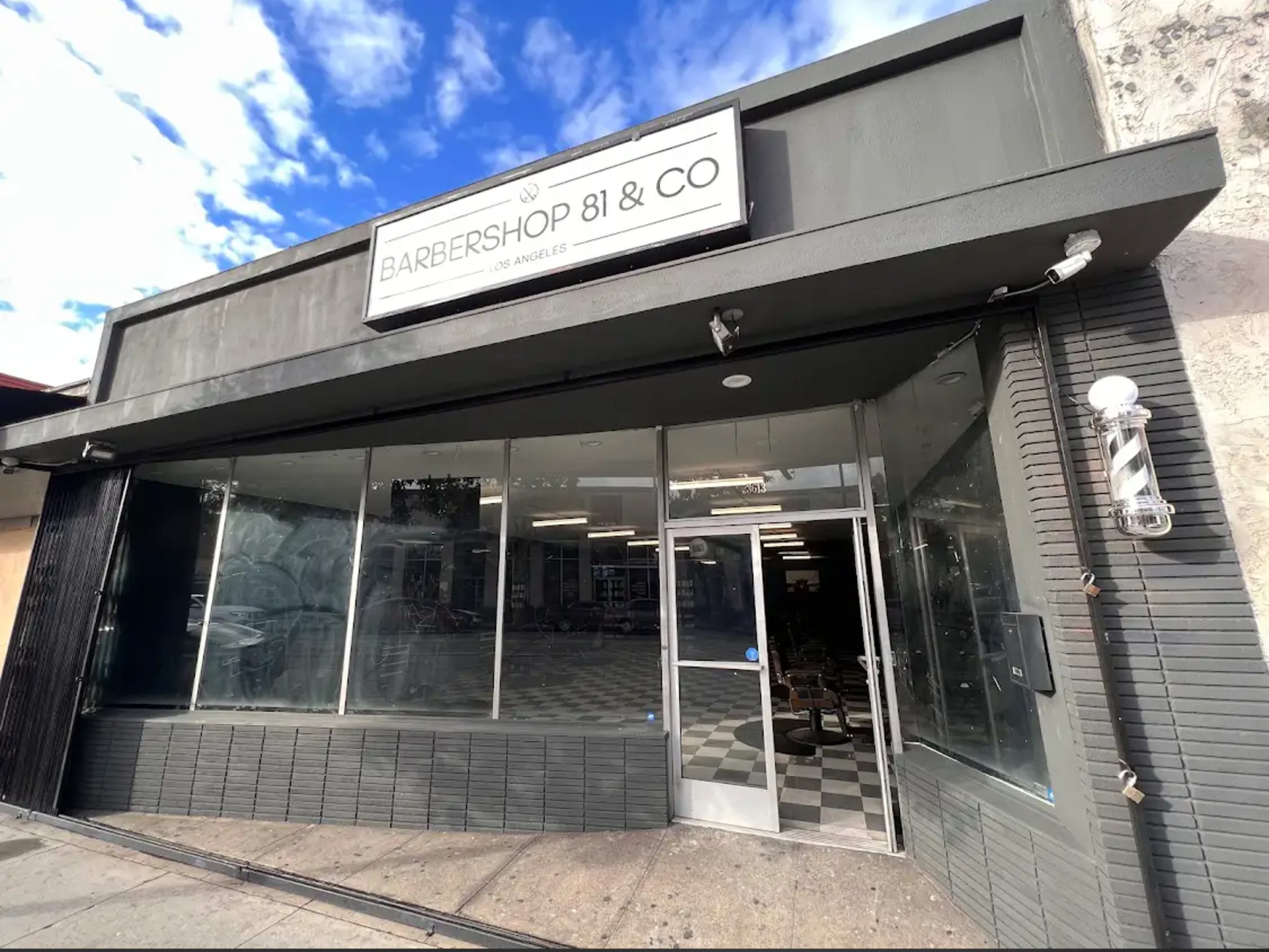 The image shows the exterior of Barbershop 81 & Co, a barber shop located in Los Angeles, featuring large windows and a checkered sidewalk.