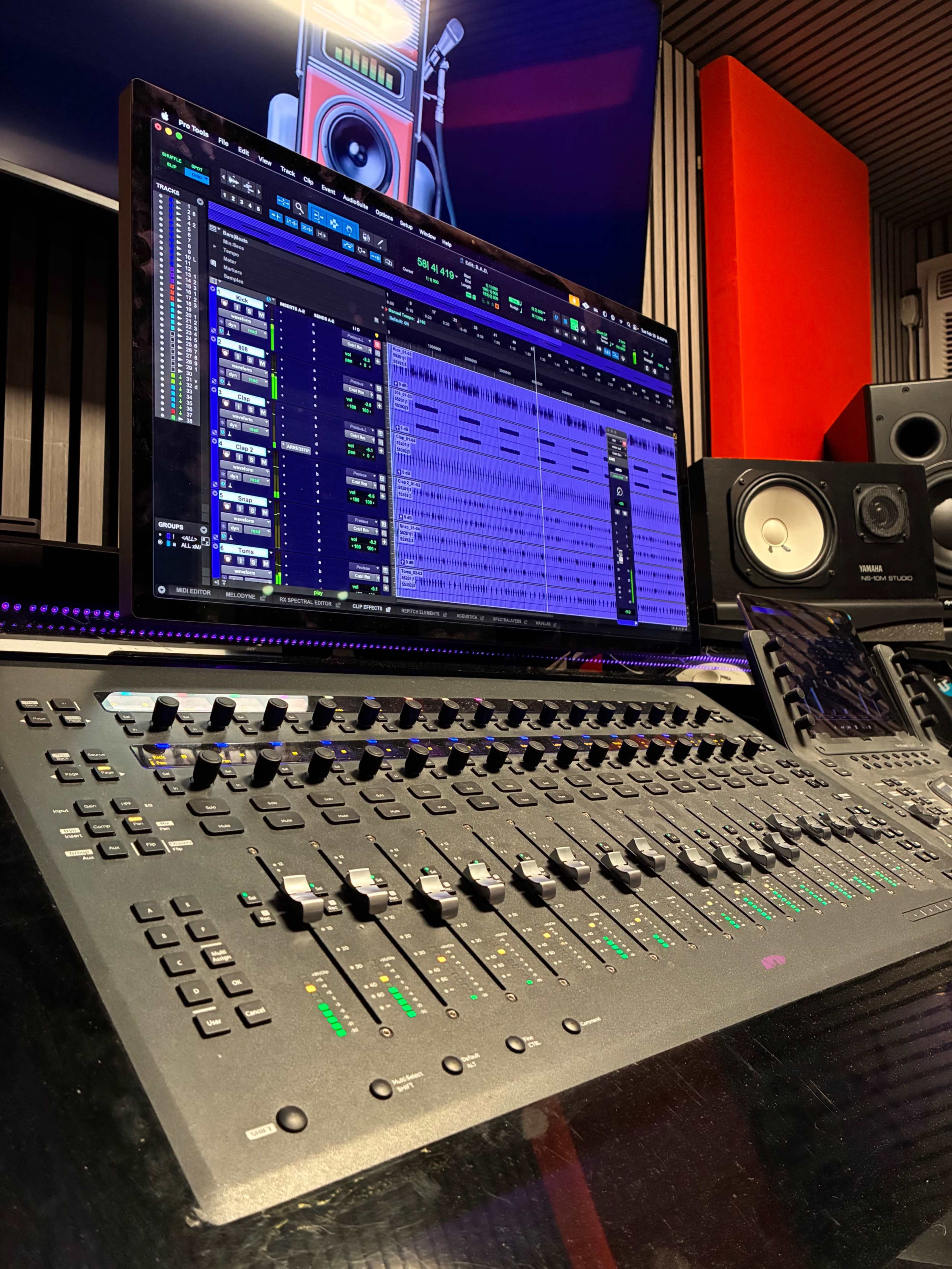 The image shows a digital audio workstation display and a mixing console in a music production studio.