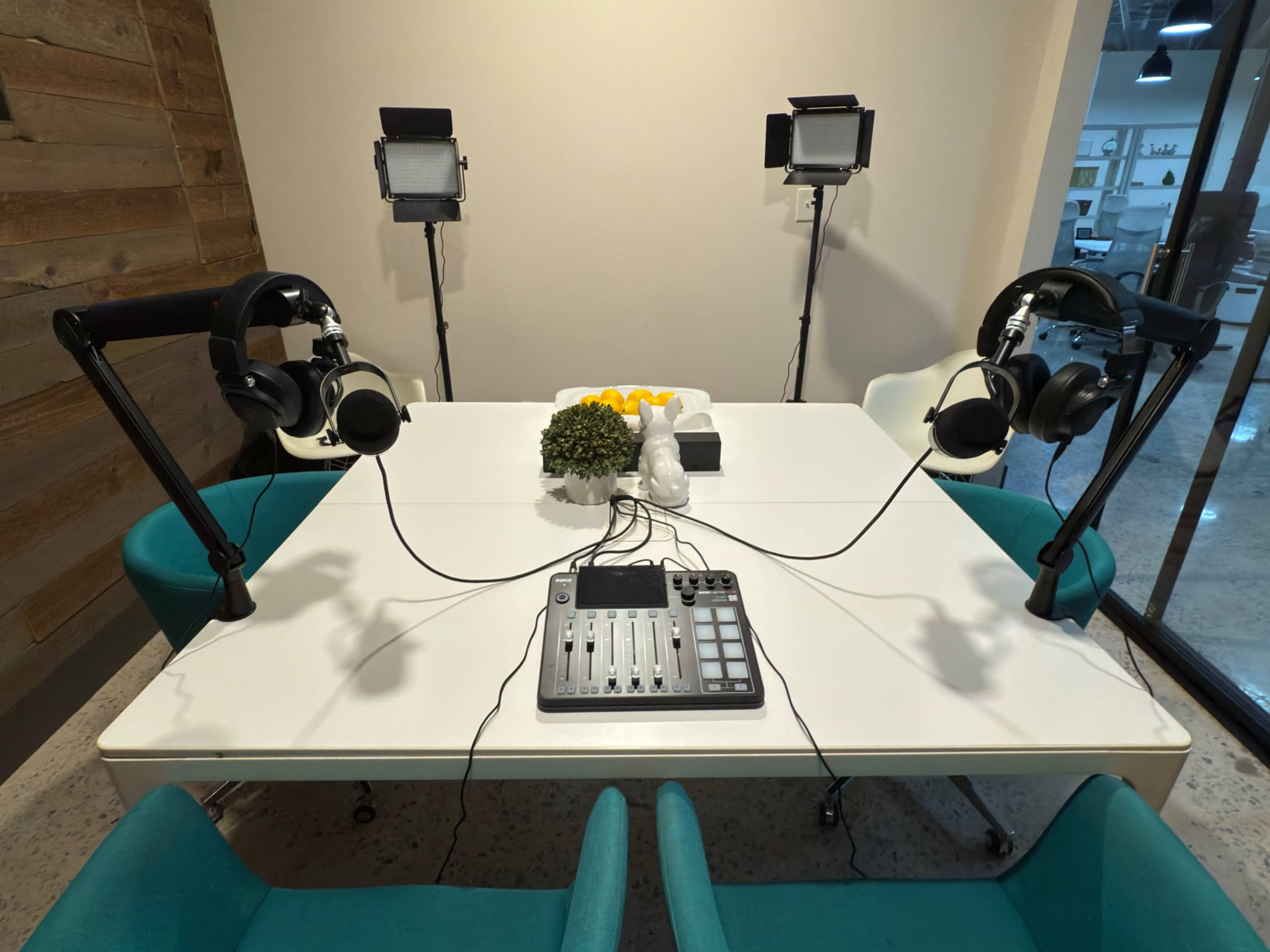A tabletop setup features a mixer with headphones on both sides and lighting equipment positioned around it.