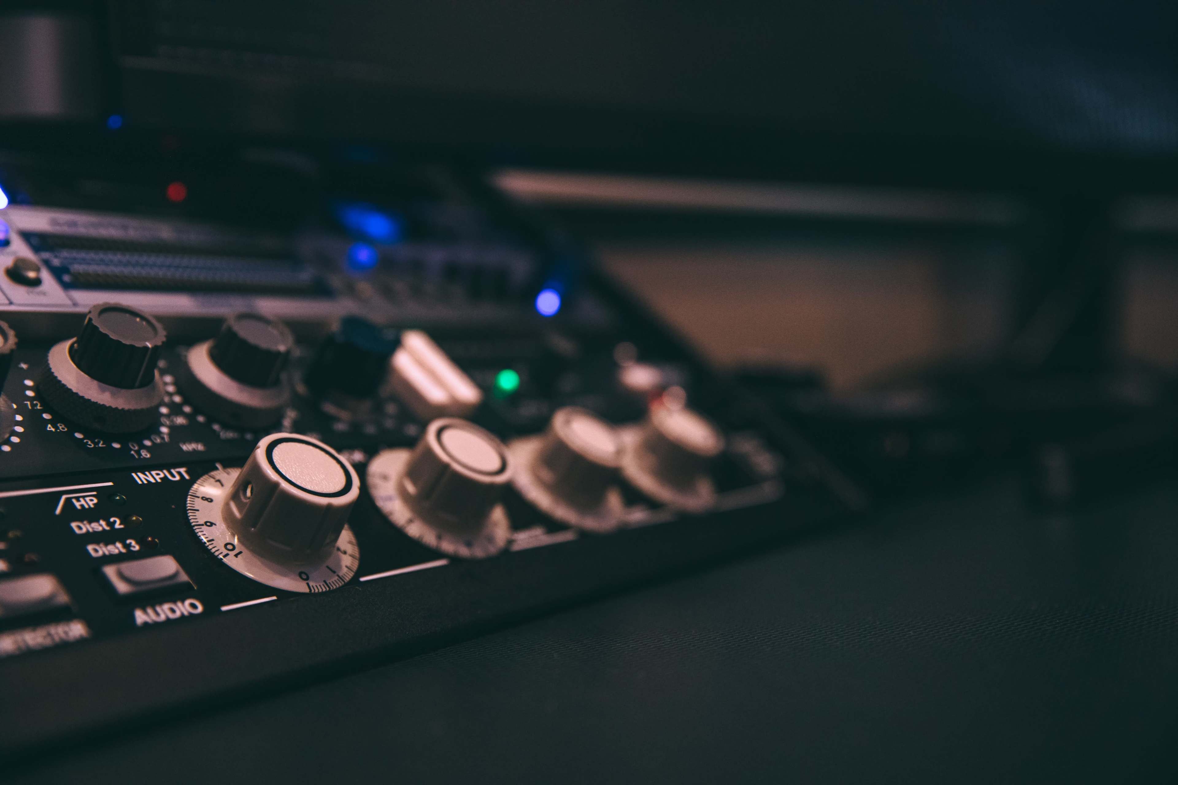 A close-up of audio equipment with various knobs and controls on a console.