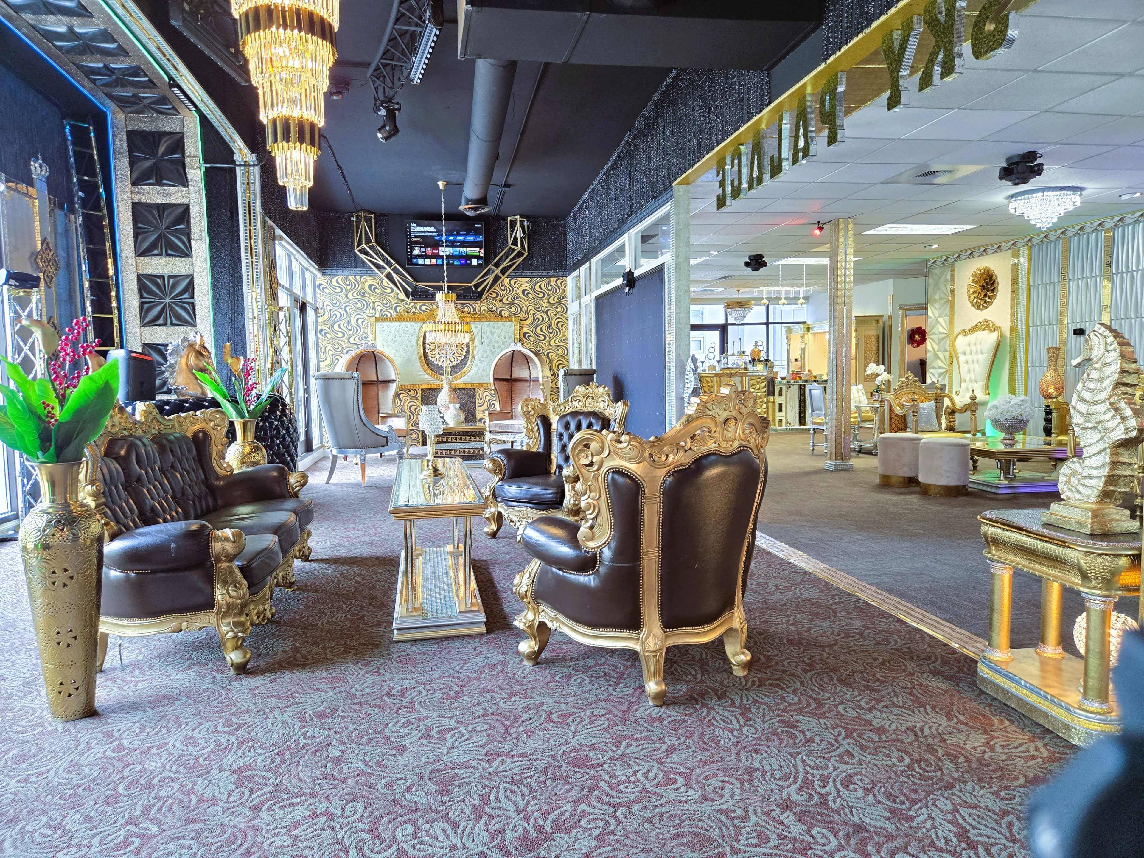 The interior features ornate, gold-accented furniture with plush, dark leather seating and decorative elements that create a luxurious atmosphere.