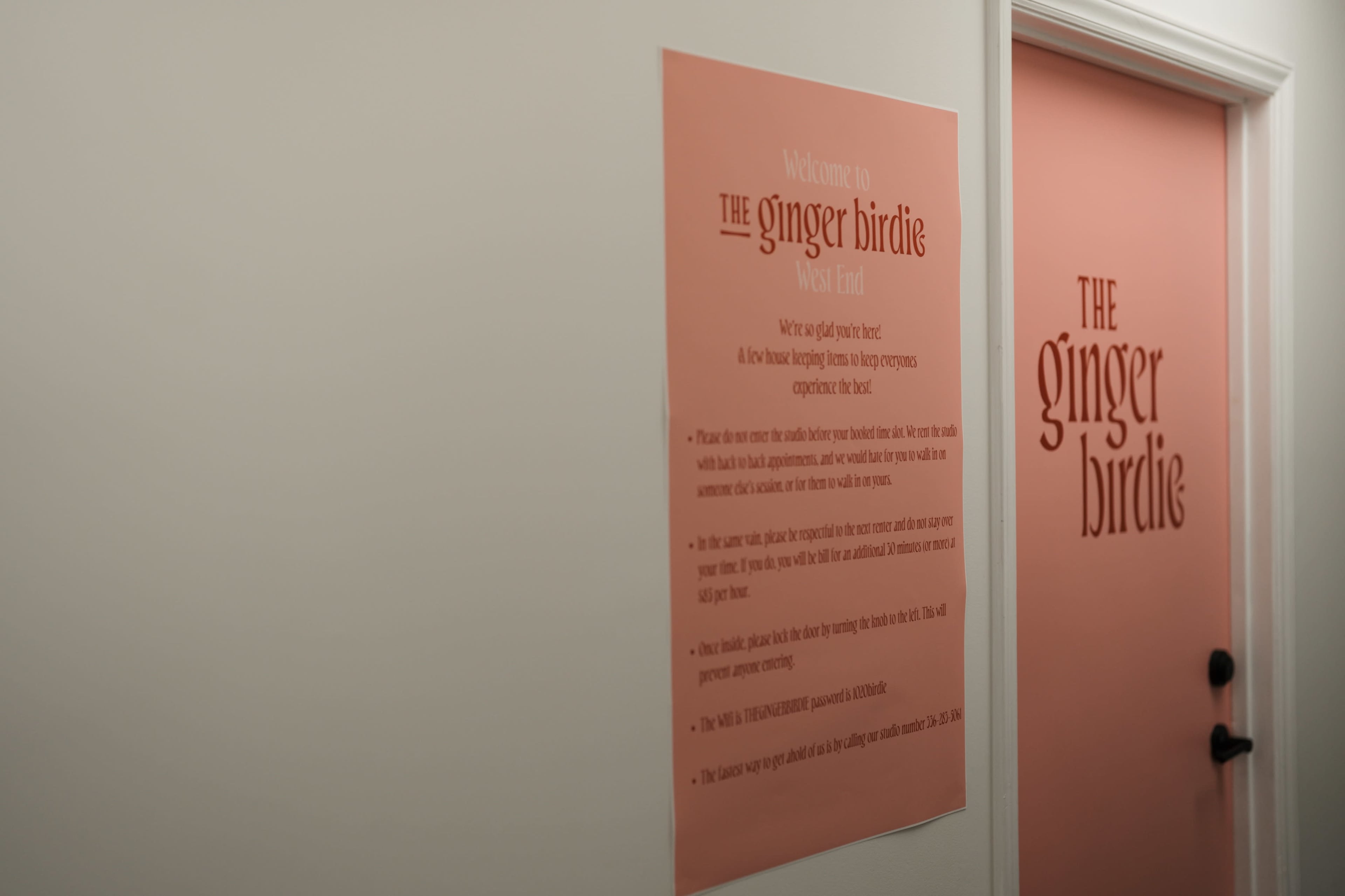 A sign mounted on a wall welcomes visitors to "The Ginger Birdie," providing instructions and information for guests.