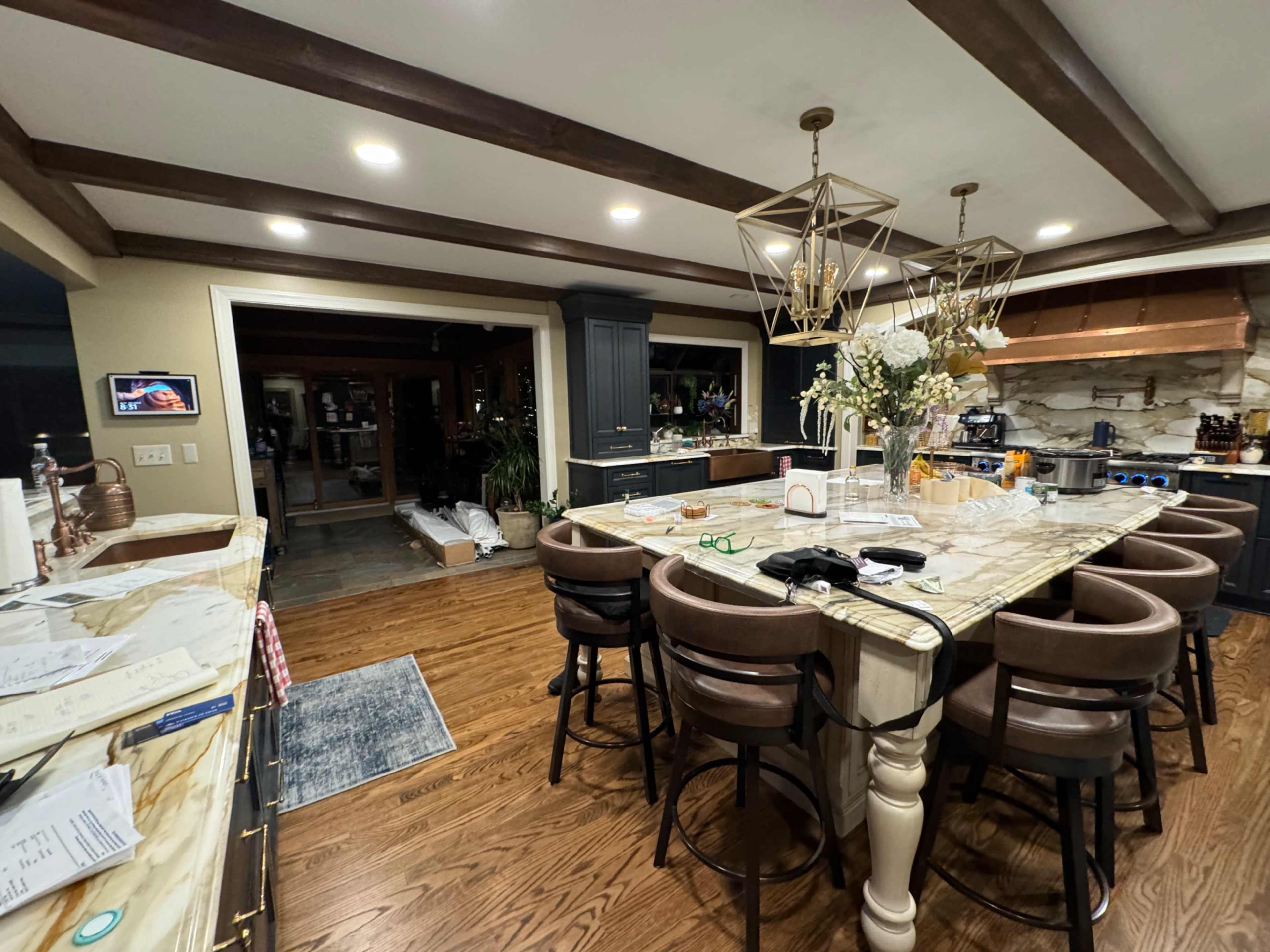 A spacious kitchen features a large island with bar seating, modern appliances, and ample natural light from windows.