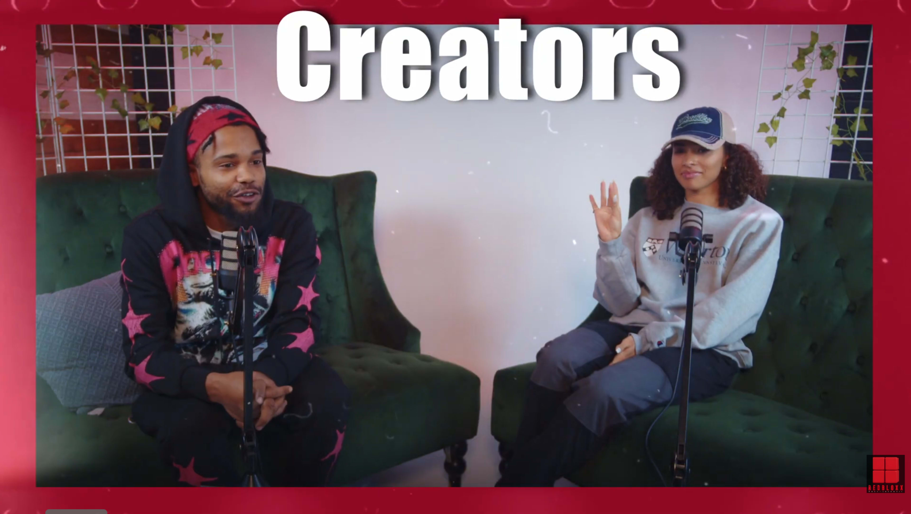 A man and a woman sit on green armchairs with microphones in front of them, while the word "Creators" is prominently displayed above them.