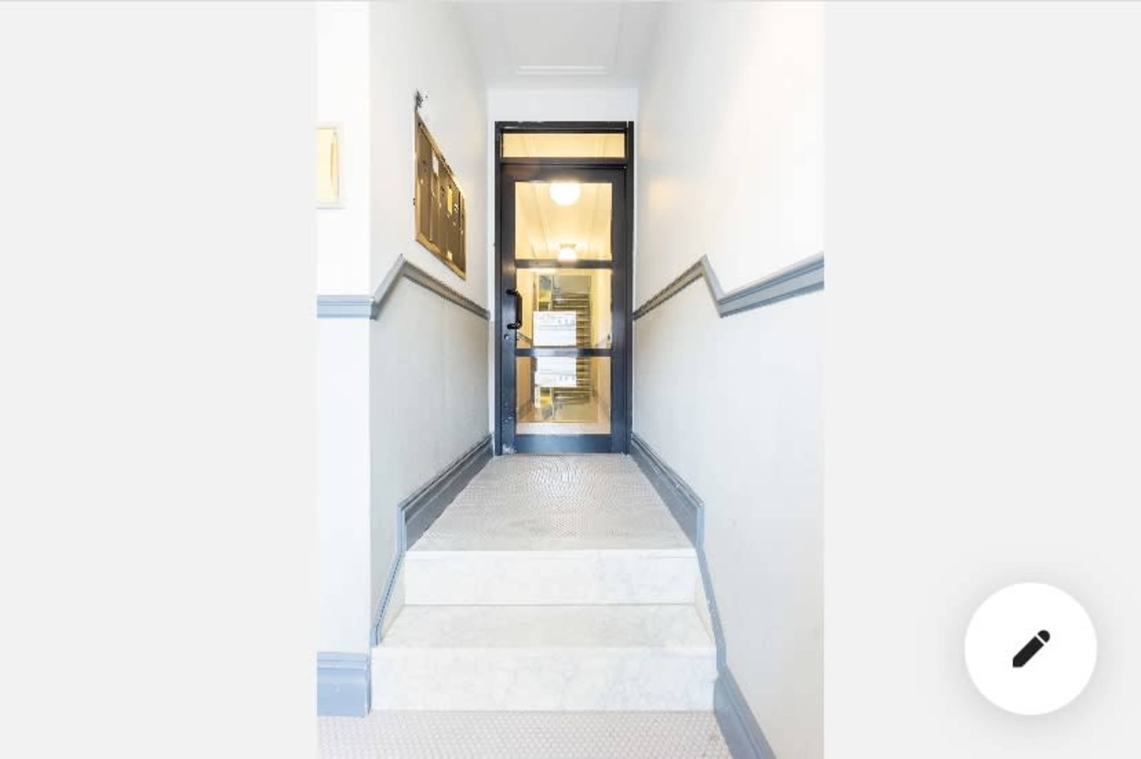 A set of stairs leads up to a glass door located at the top, with a notice posted on it.