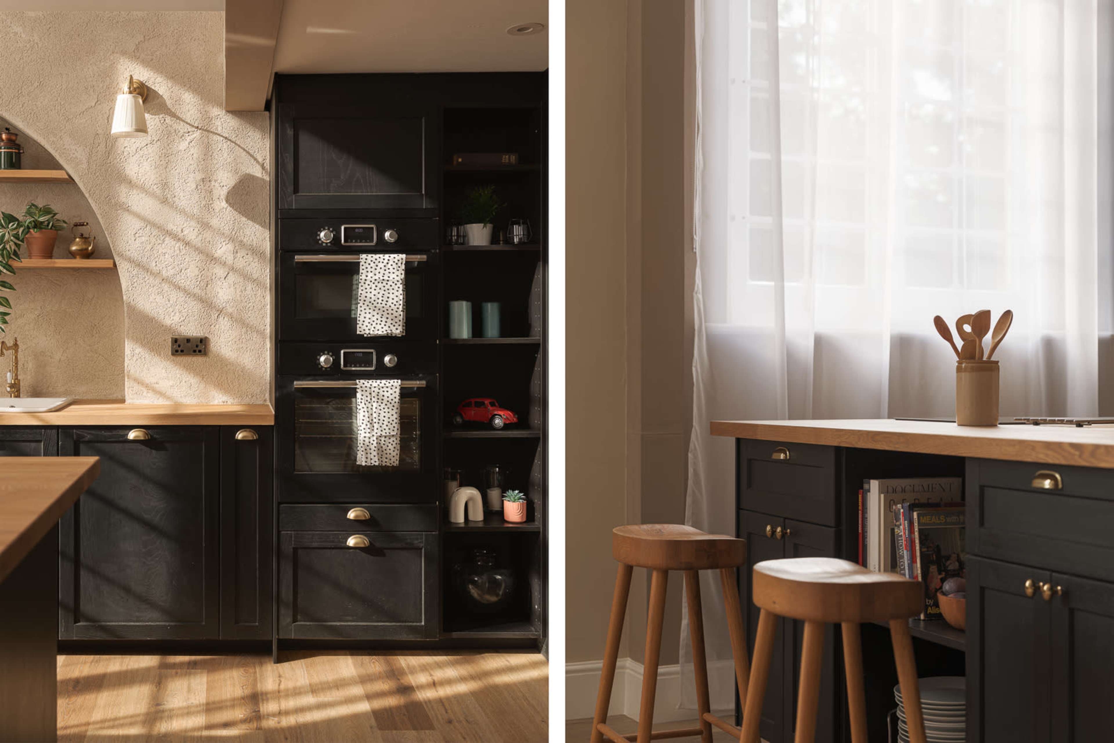 The image displays a modern kitchen featuring dark cabinetry with built-in appliances on the left and a small breakfast nook with wooden stools and utensils on the right.