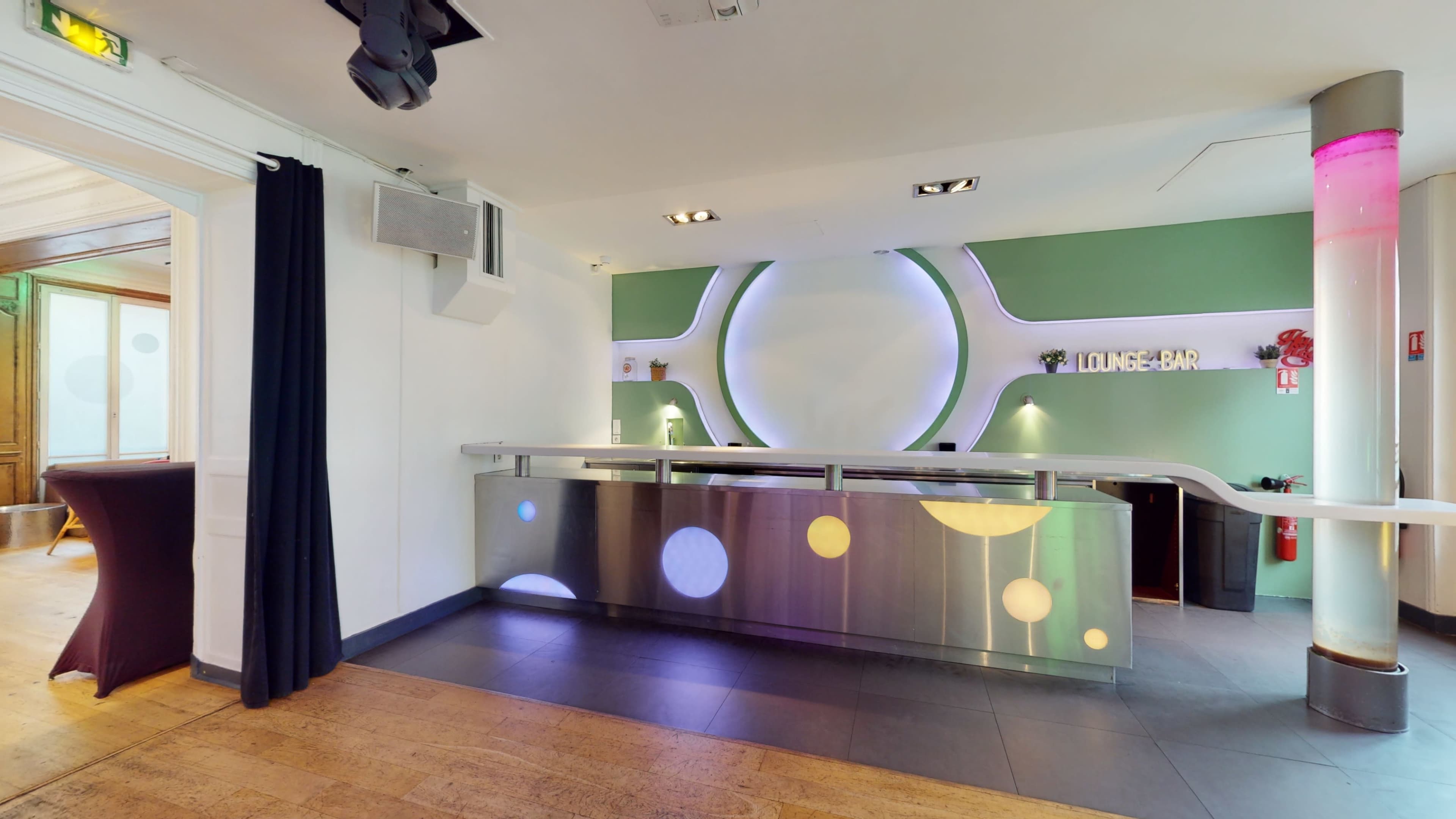 A modern reception area with a sleek bar counter featuring circular designs and ambient lighting.