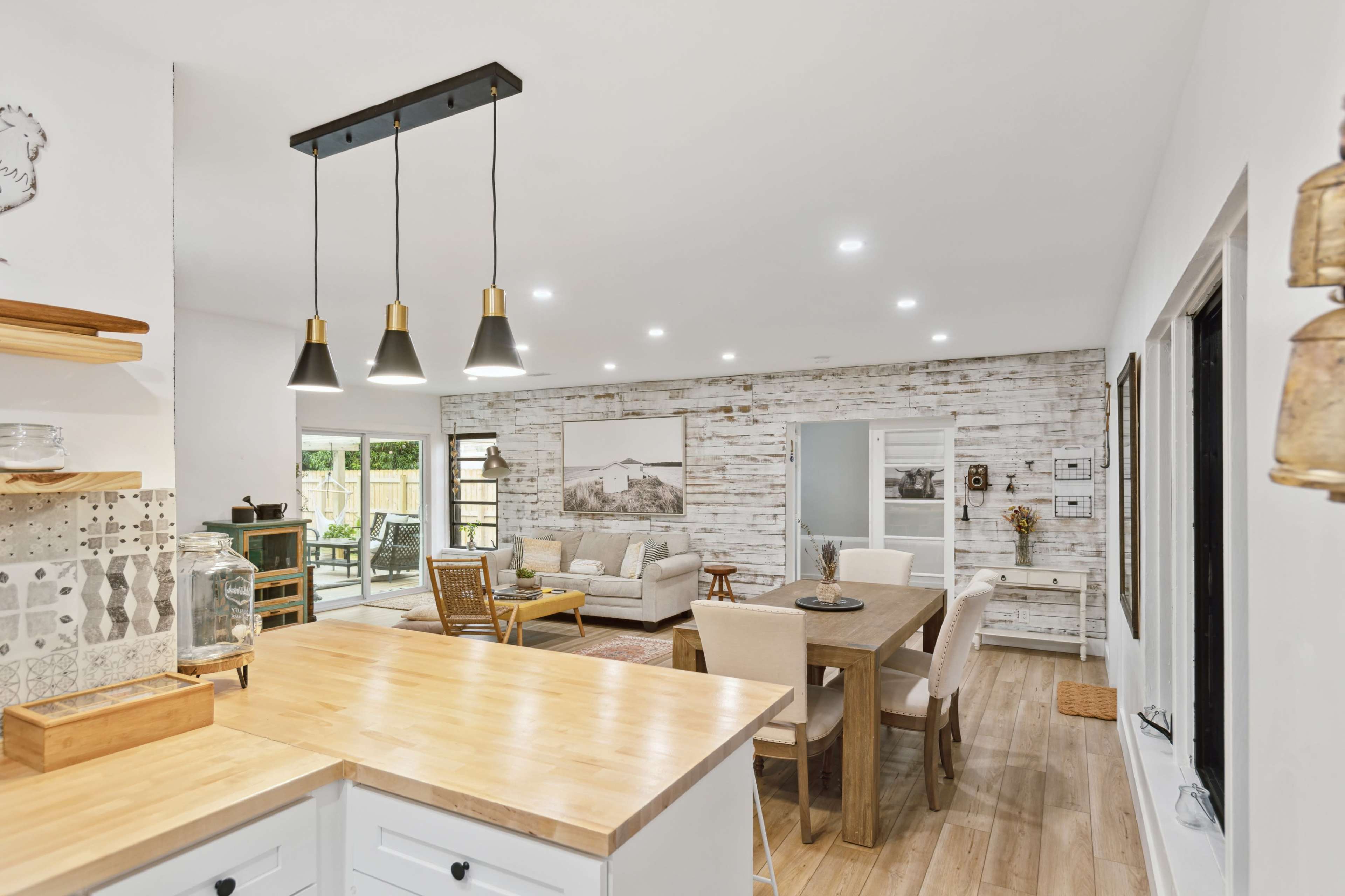 A modern, open-concept living and dining area with light wooden flooring and a mix of contemporary and rustic decor.