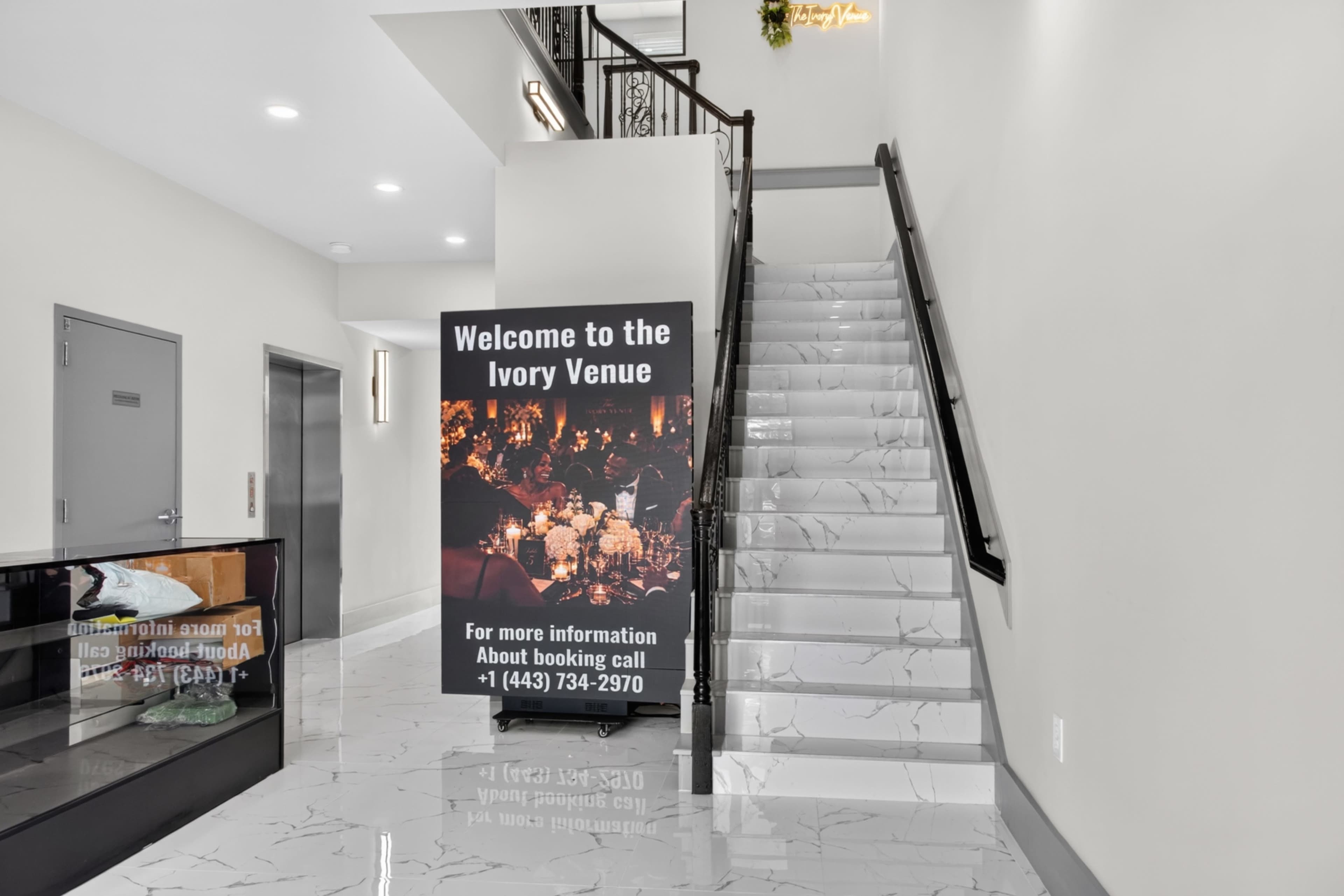 A staircase leads up to a venue, with a large sign that reads "Welcome to the Ivory Venue" and provides contact information for bookings.