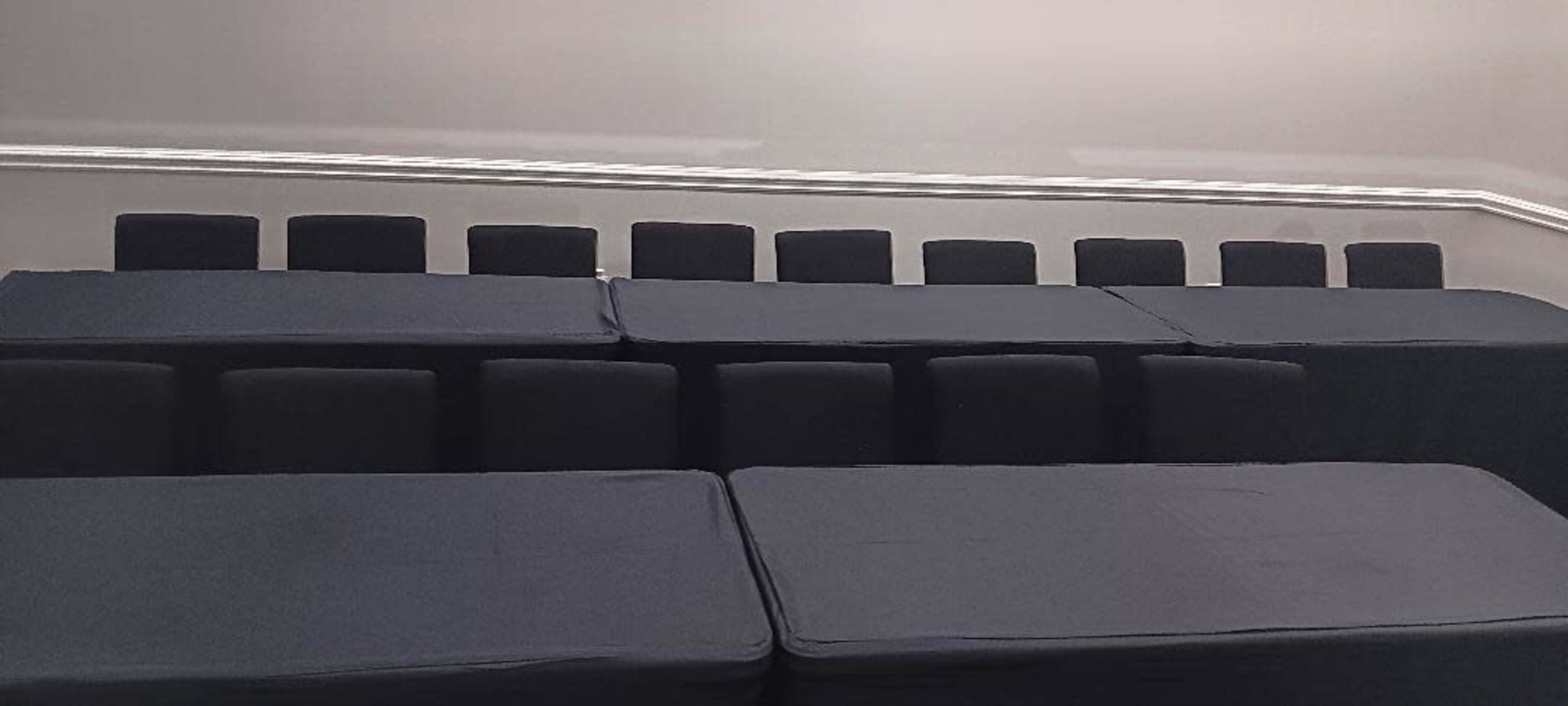 A series of stacked black cushions arranged on a flat surface.