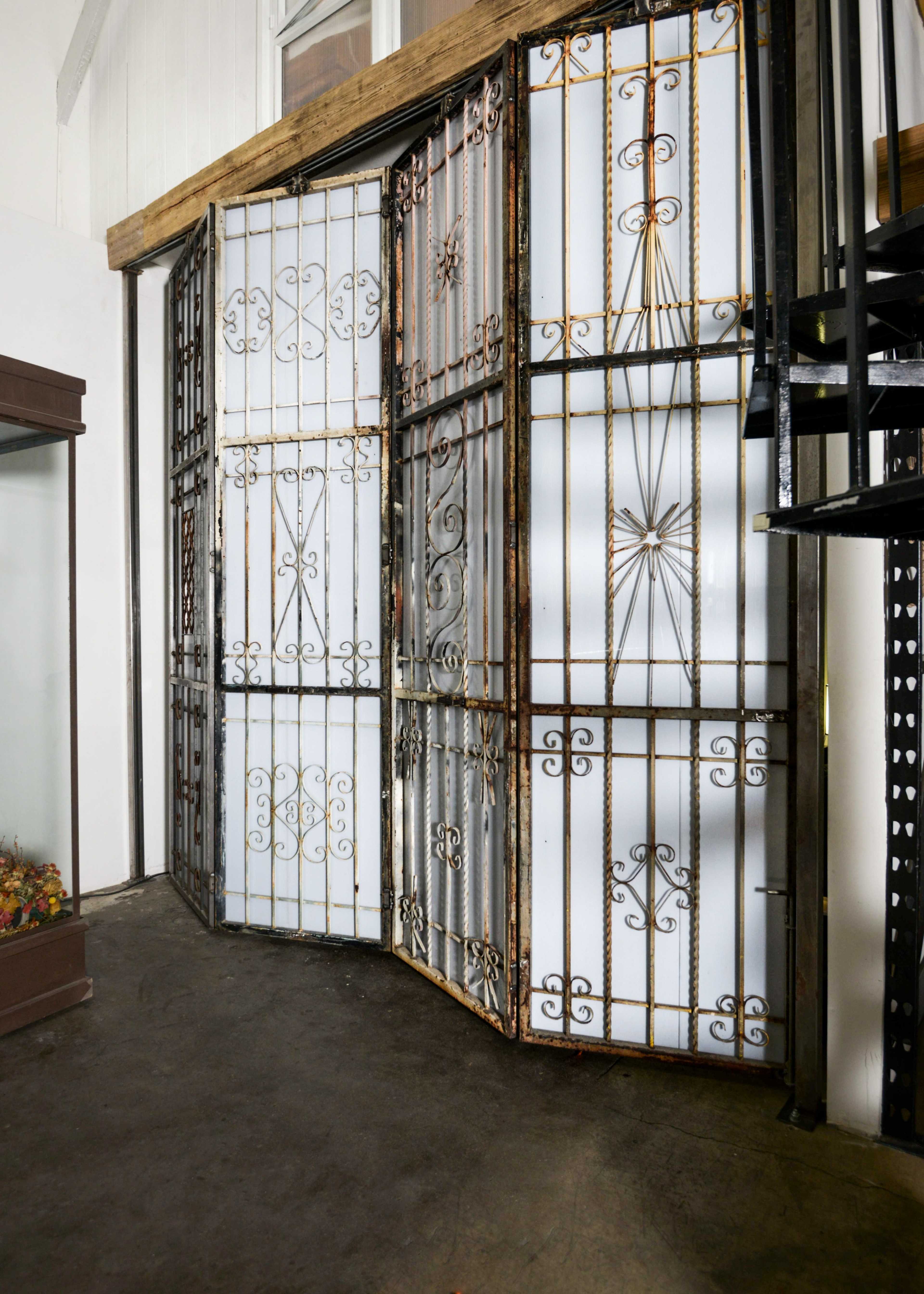 The image shows a set of decorative metal security doors that are partially opened, revealing a storage area behind them.