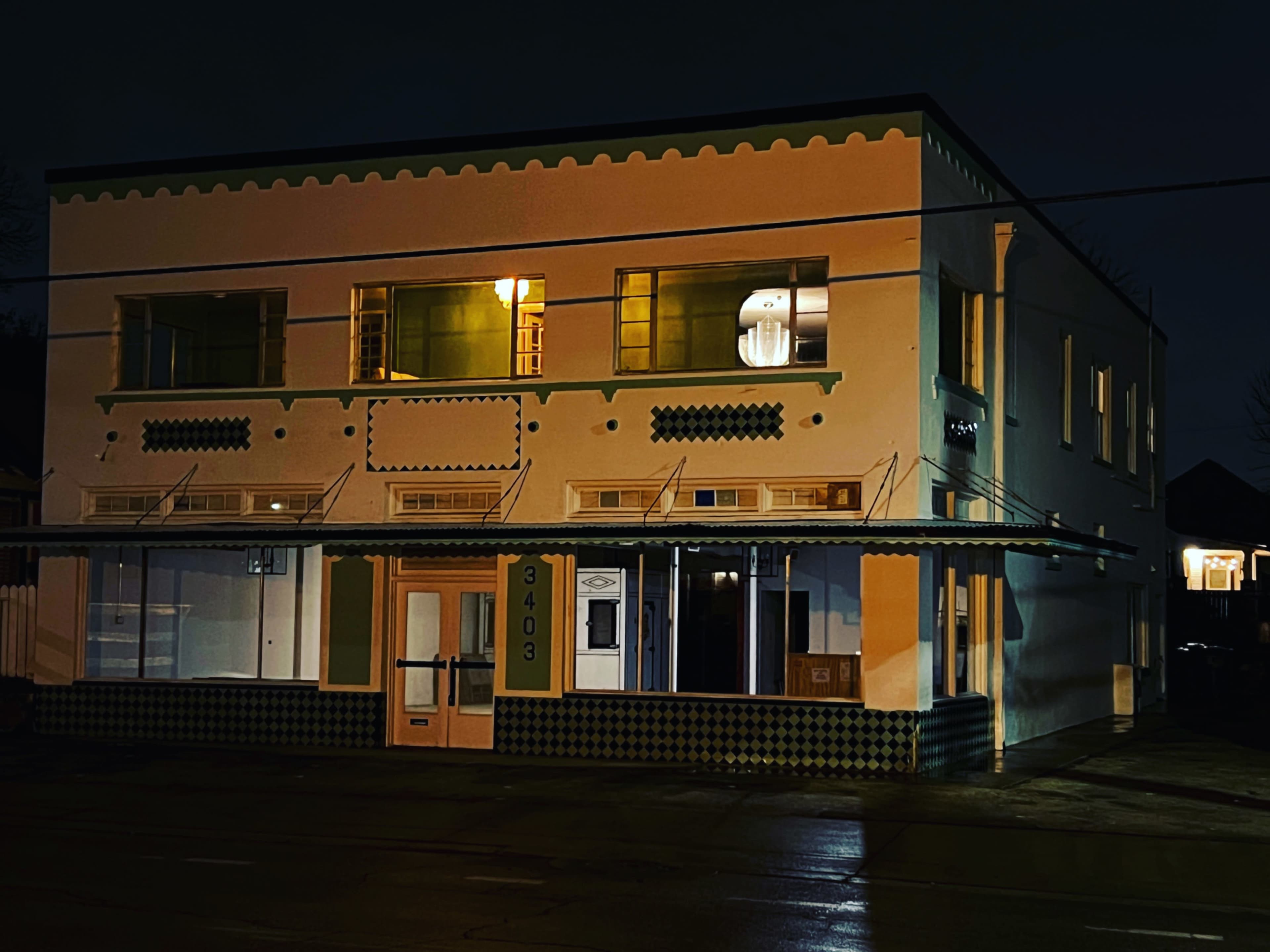A two-story building at night, featuring a distinct architectural style with colorful details and large windows.