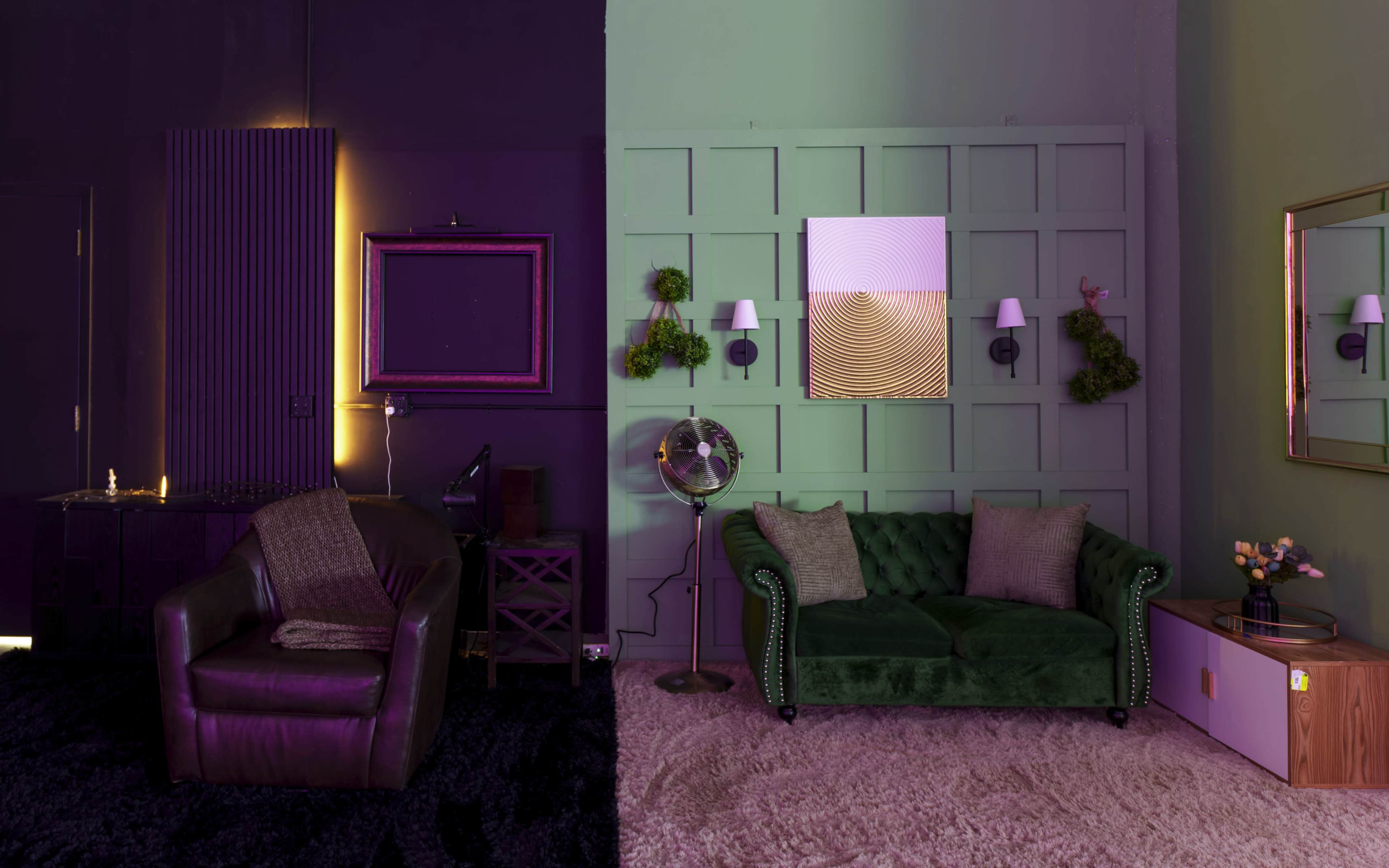 The image features a split scene of two contrasting living spaces, one with a dark purple theme and a leather armchair, and the other with a green theme showcasing a velvet sofa and decorative wall elements.