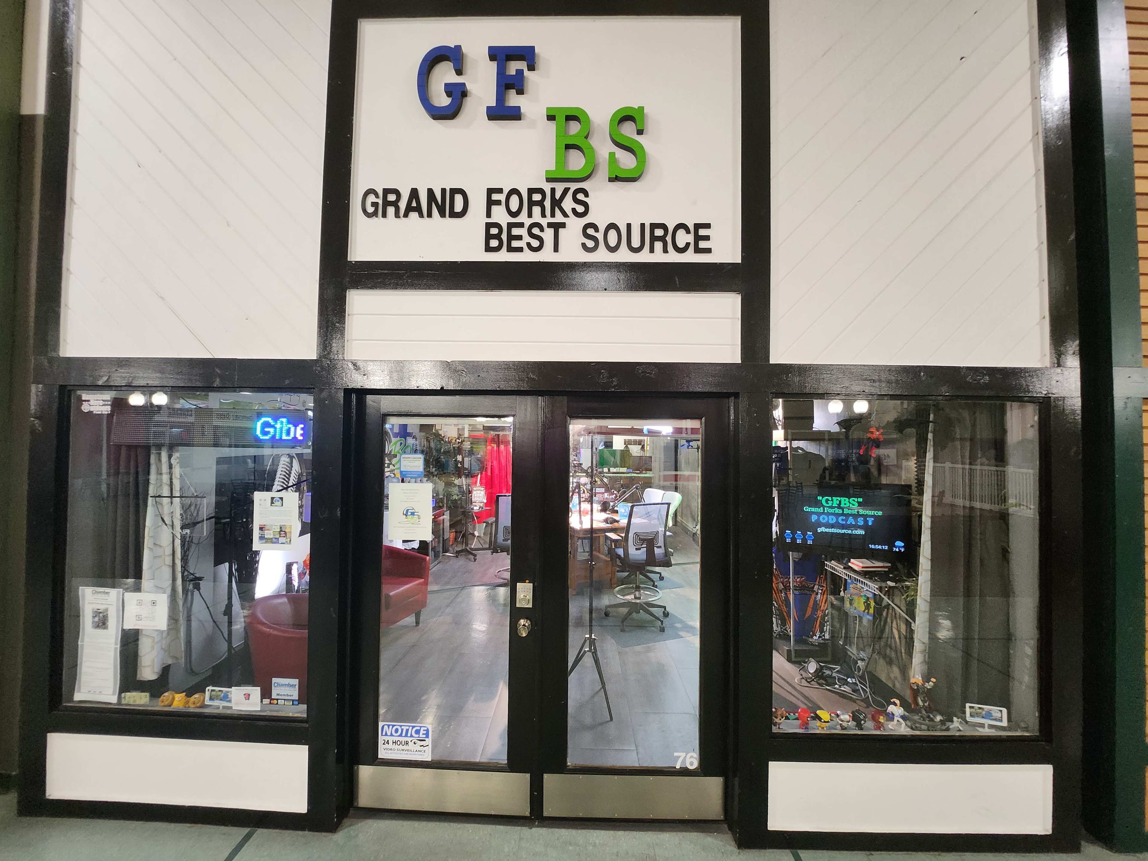 The storefront of a business called "Grand Forks Best Source," featuring a logo and a clear display of its services inside.
