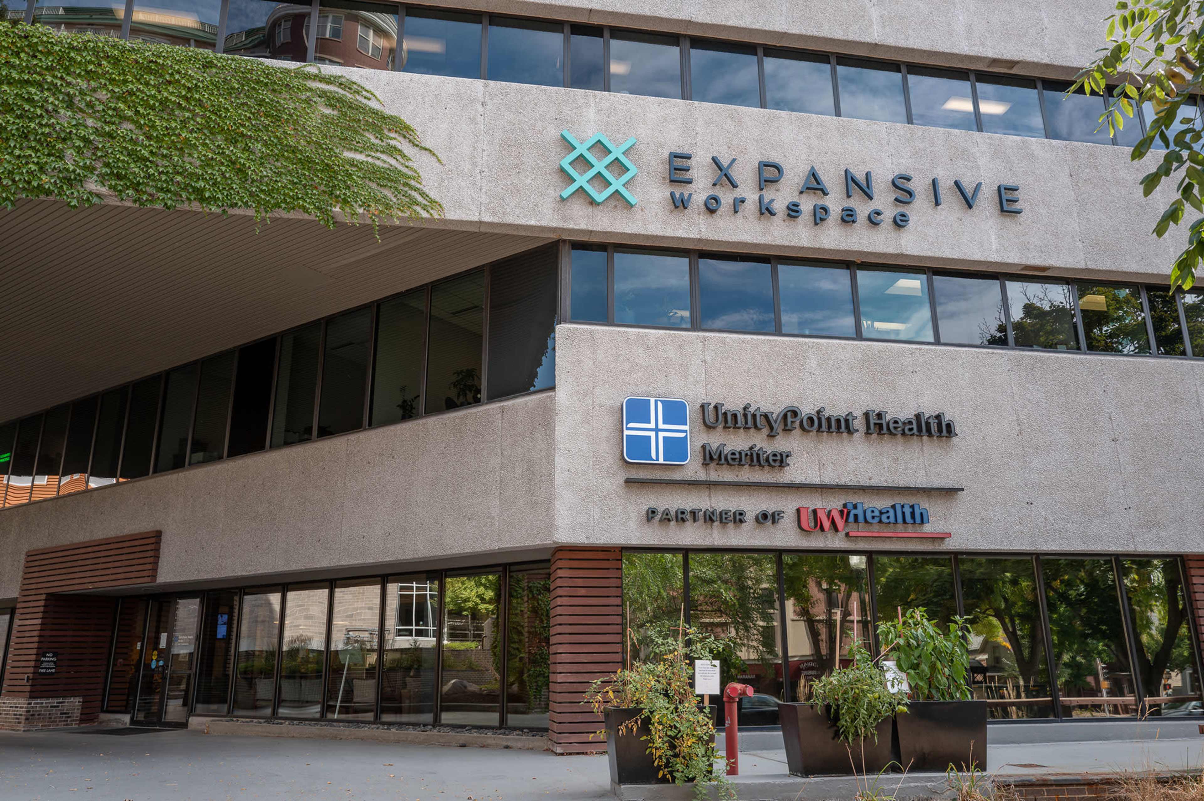The image shows a modern building with the signage for Expansive Workspace and UnityPoint Health, indicating collaboration with UW Health.
