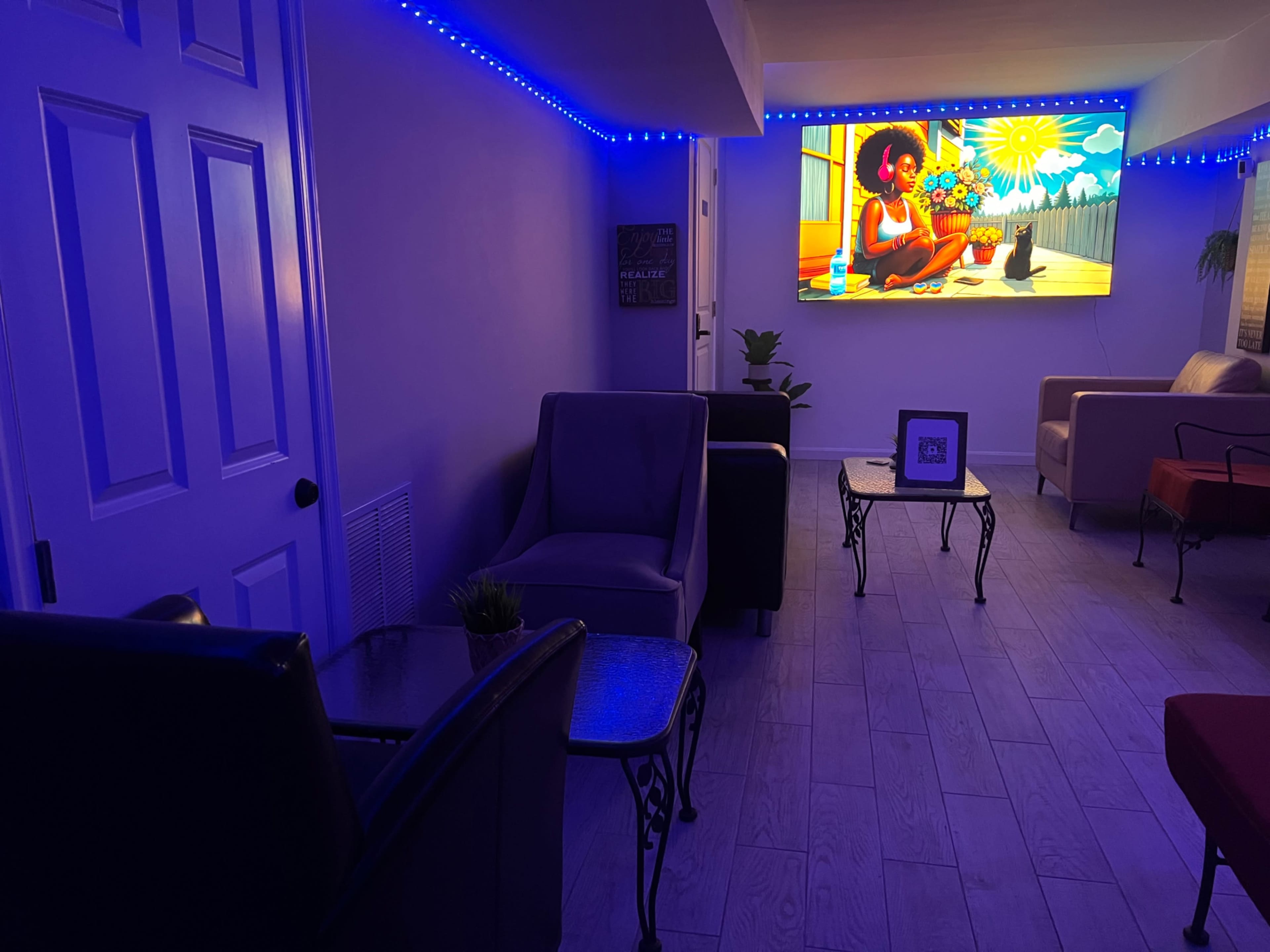 A cozy living room features modern furniture, purple ambient lighting, and a large television displaying a colorful scene.