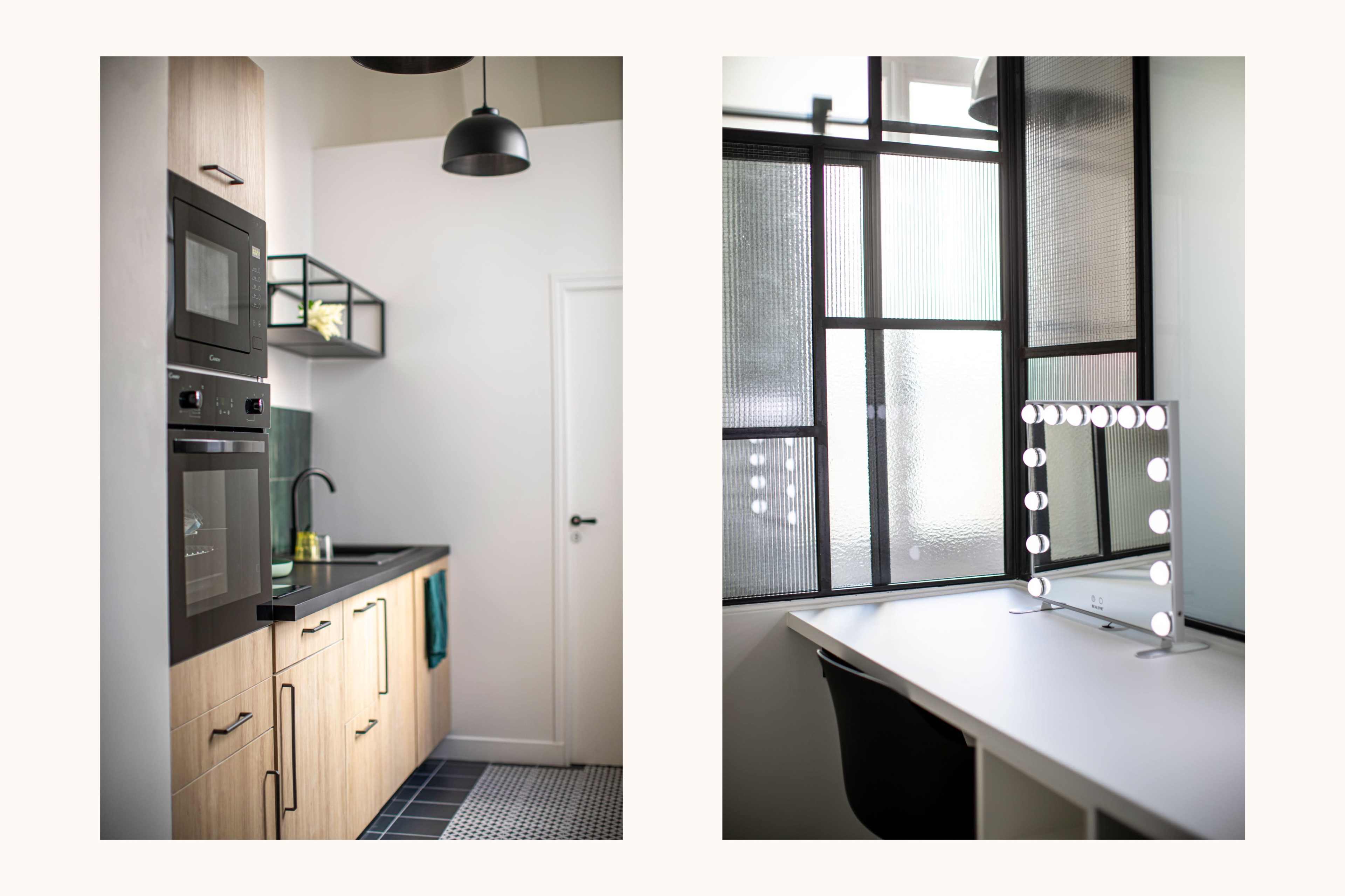 A modern kitchen on the left with wooden cabinets and built-in appliances, and a bright workspace on the right featuring a mirror with lights beside a window.