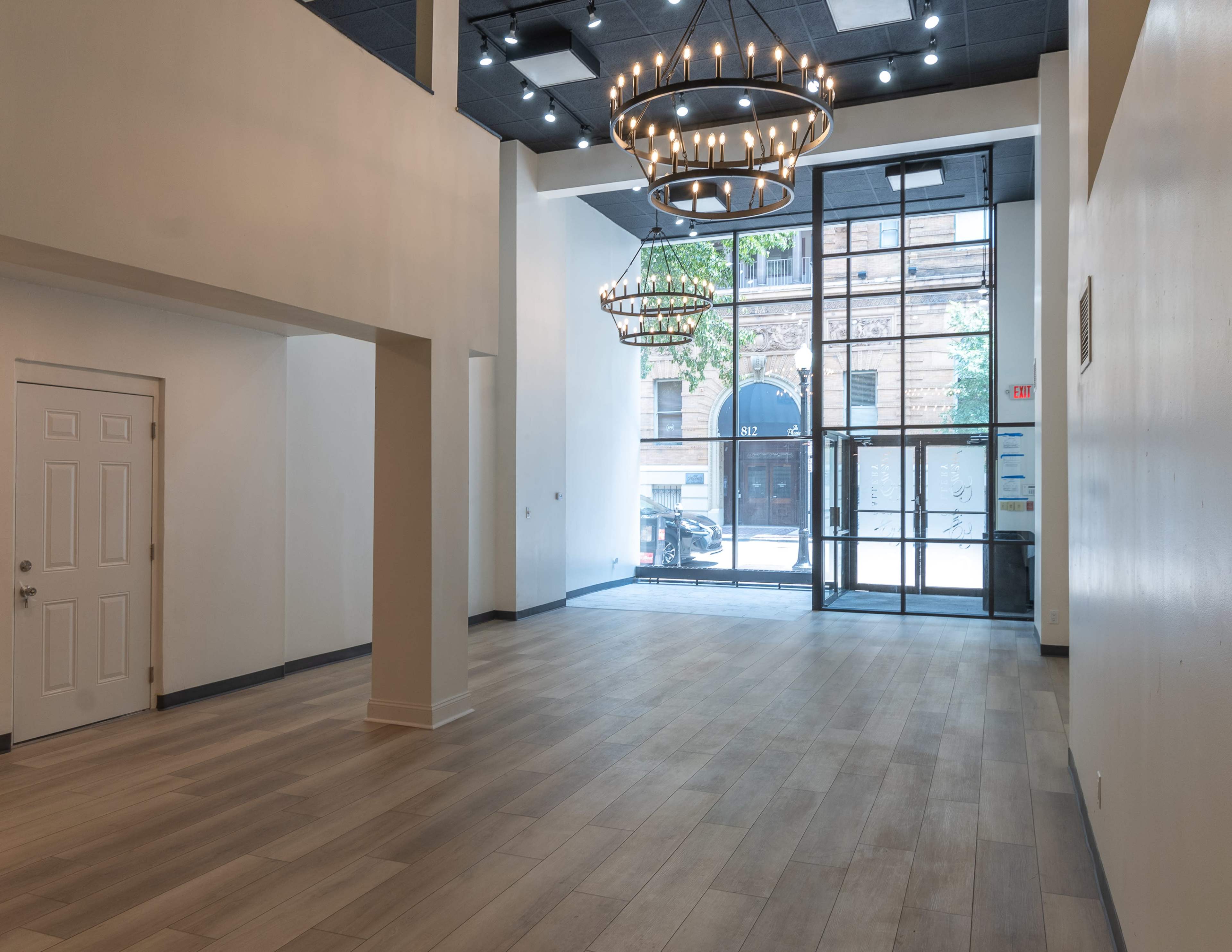 A spacious, modern interior with hardwood floors, high ceilings, and large windows that allow natural light to enter.