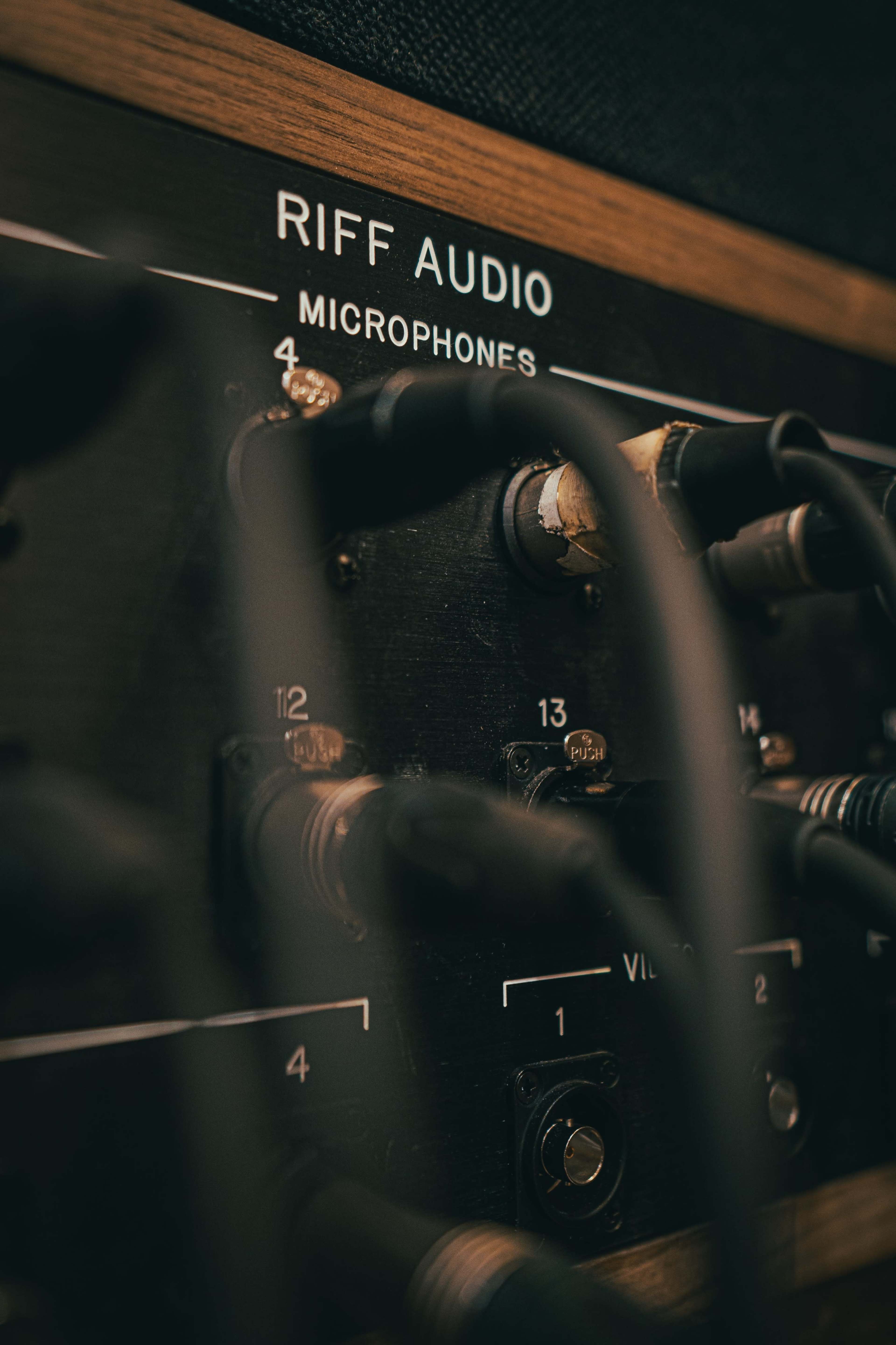 The image shows a close-up of a microphone panel with labeled inputs and several connected cables.