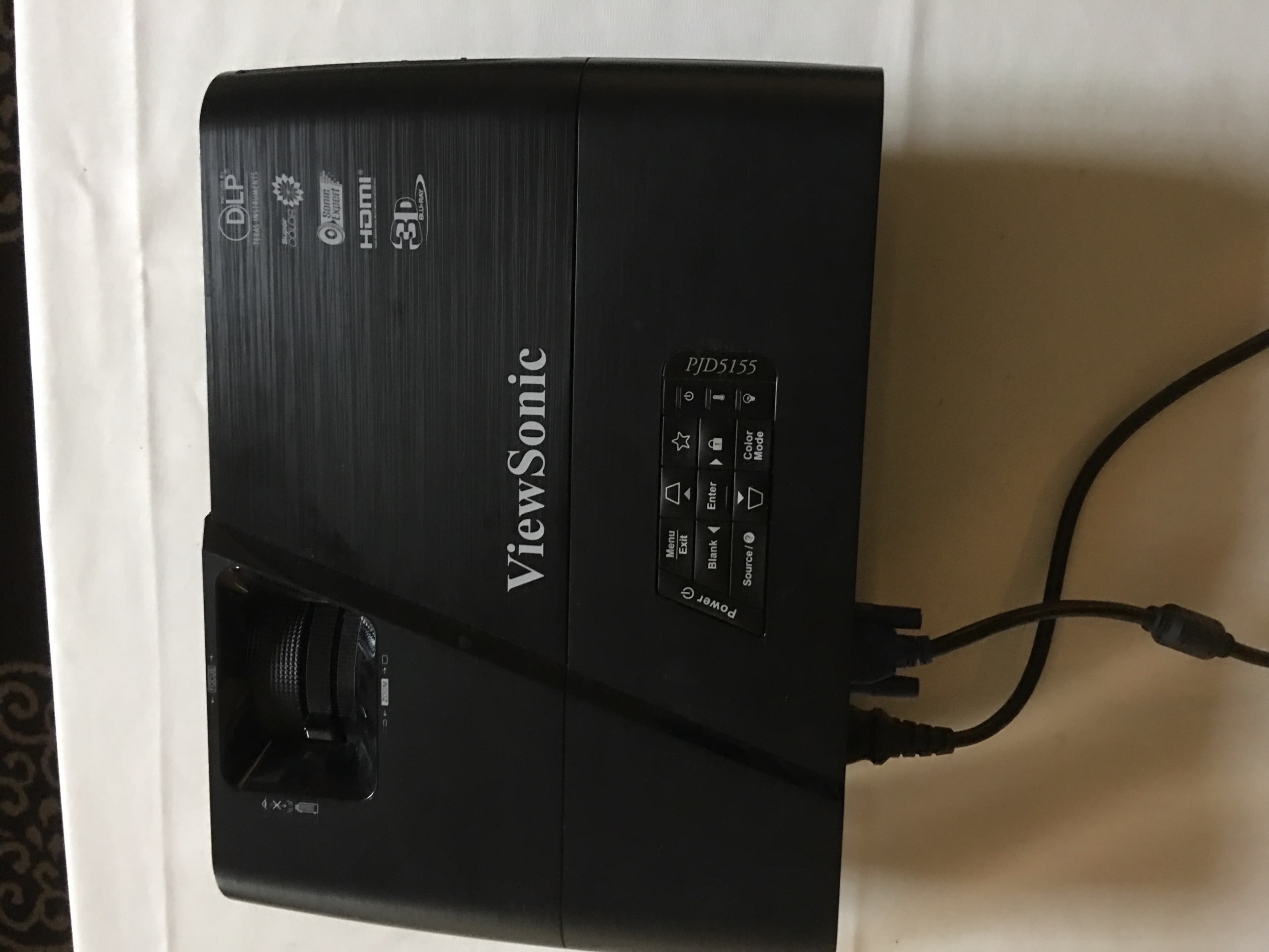 A ViewSonic projector with various input options and control buttons on a black surface.
