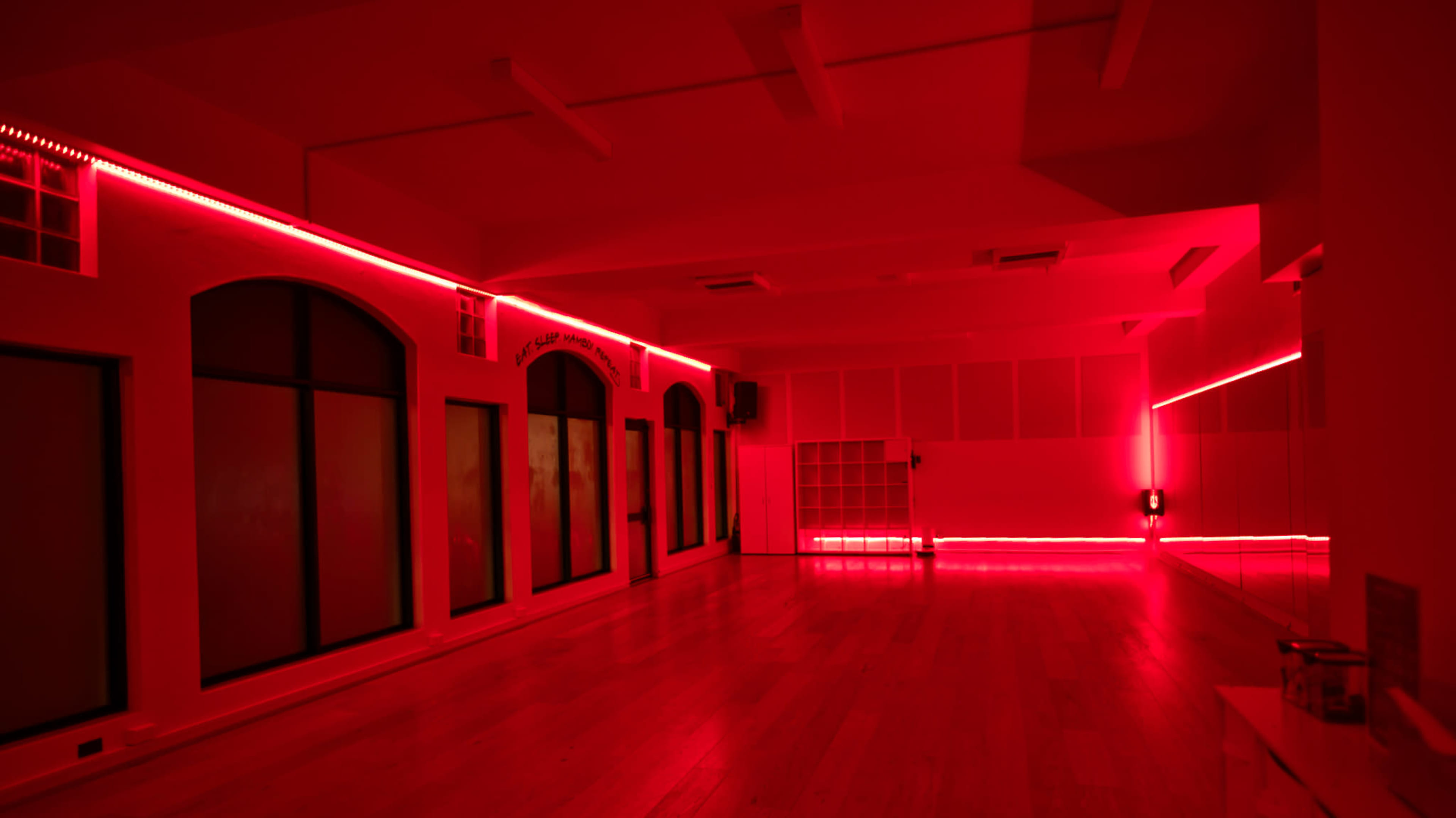 The room features a wooden floor and walls illuminated with red LED lights, creating a dramatic ambiance.