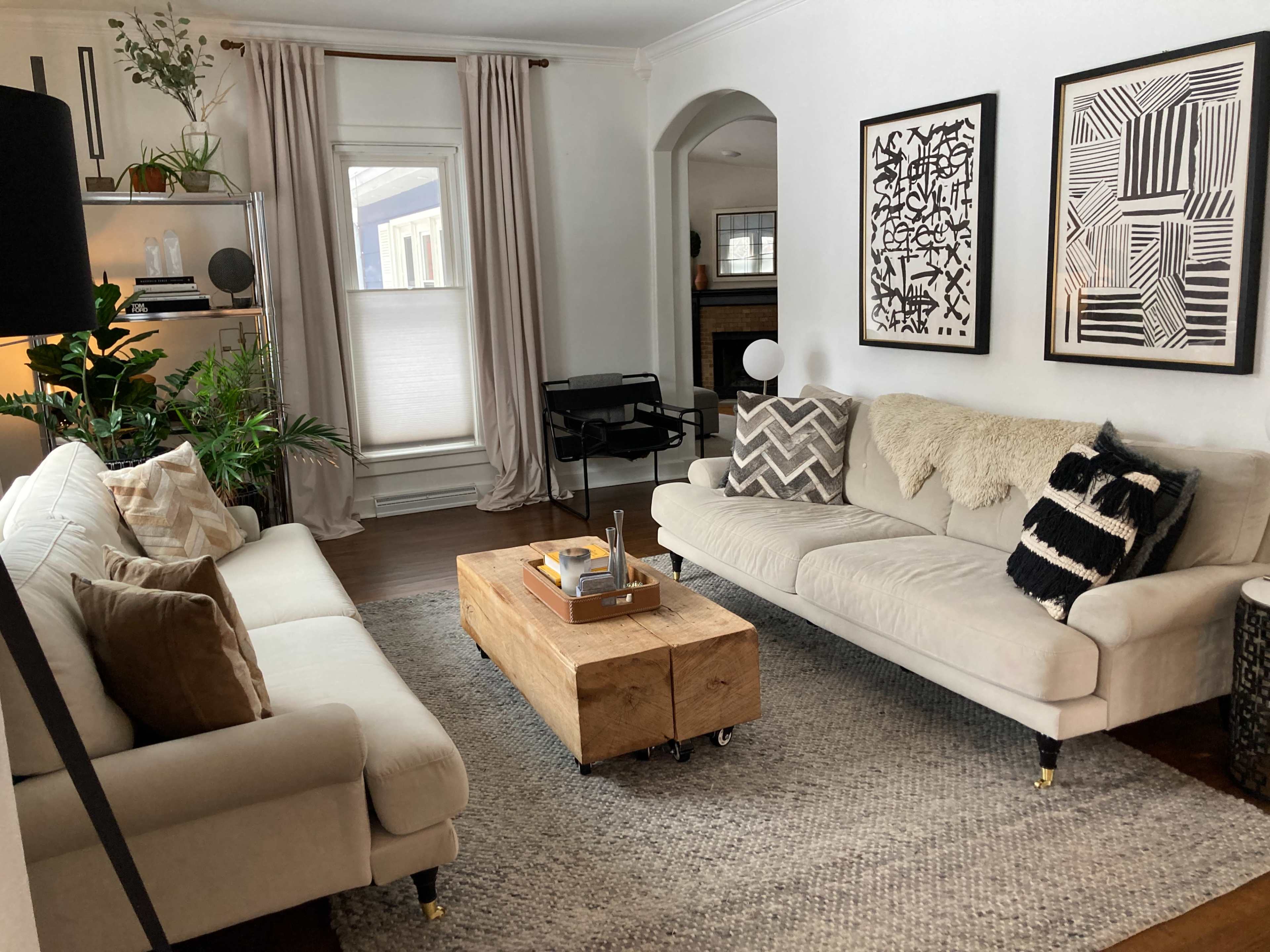 The living room features two sofas facing each other, a wooden coffee table in the center, and framed artwork on the walls.