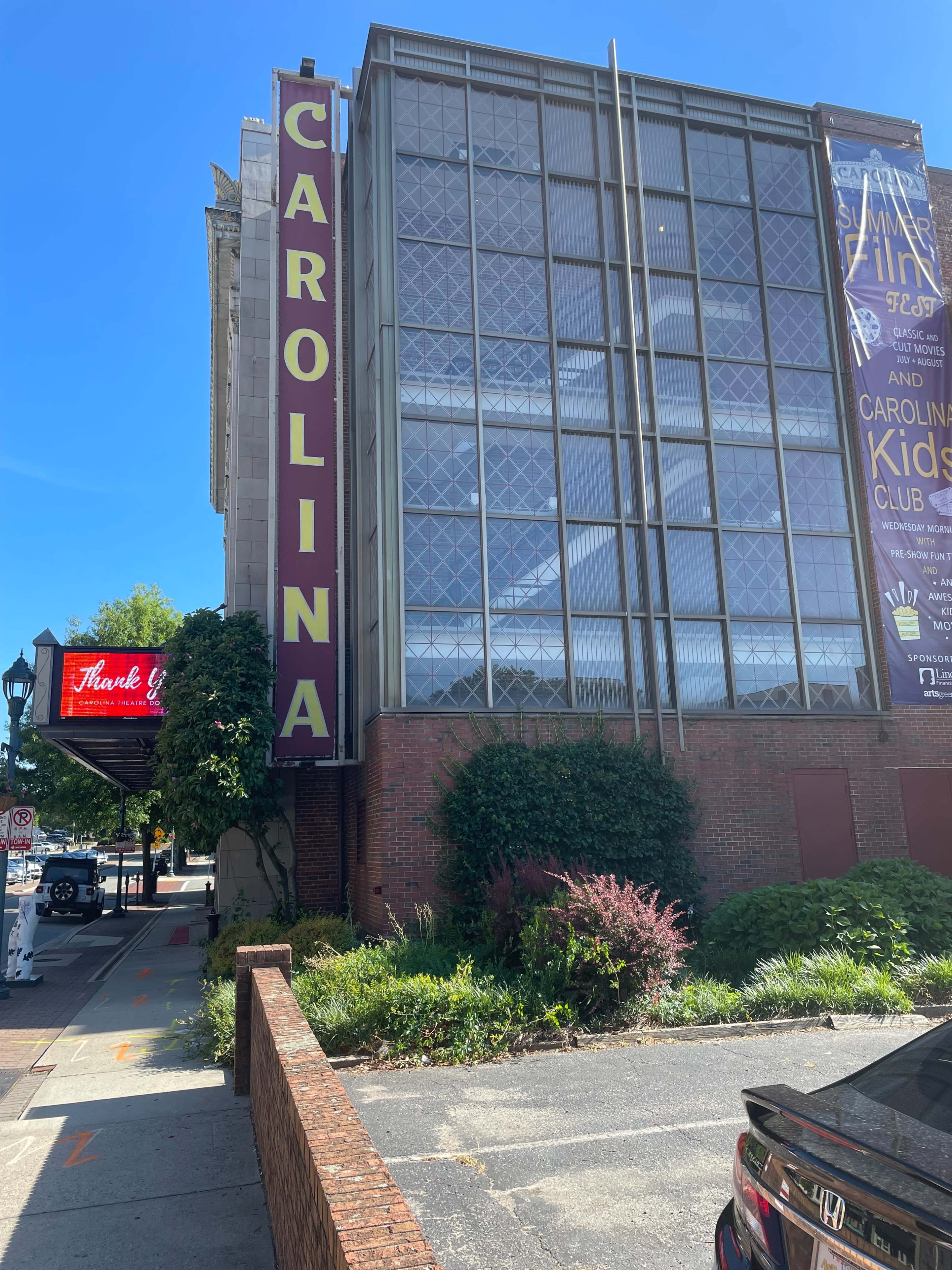 A building with the word "CAROLINA" prominently displayed on its side, featuring a mix of glass and brick architecture.