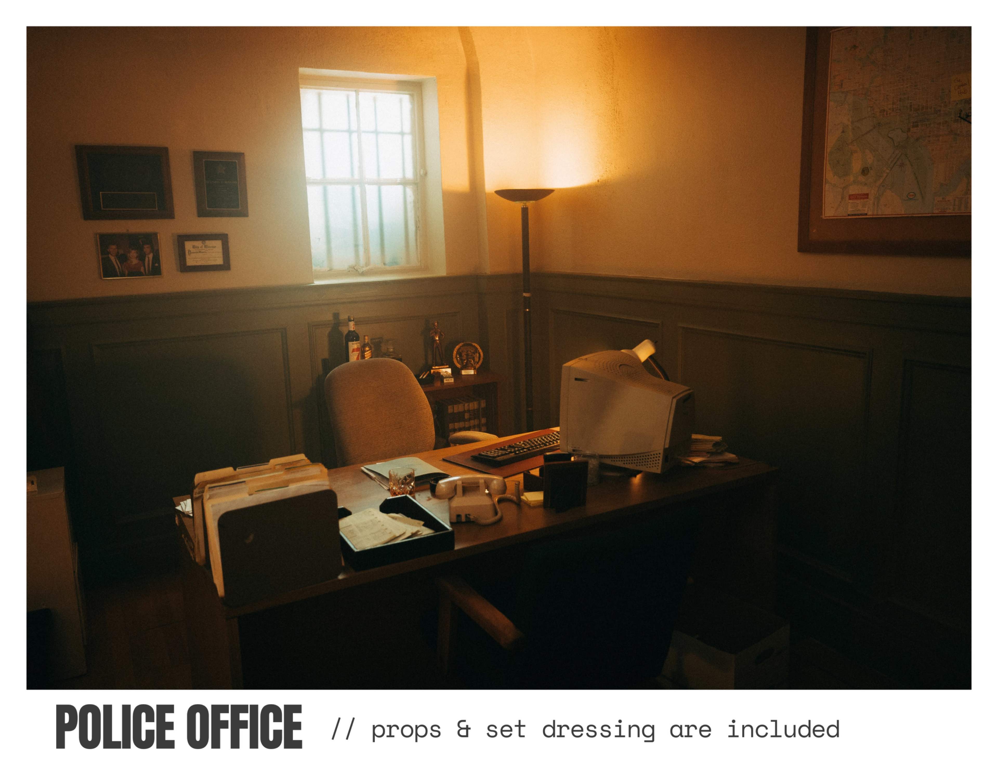 The image depicts a dimly lit police office featuring a desk with an old computer, a chair, and various office supplies against a backdrop of a window and wall decor.