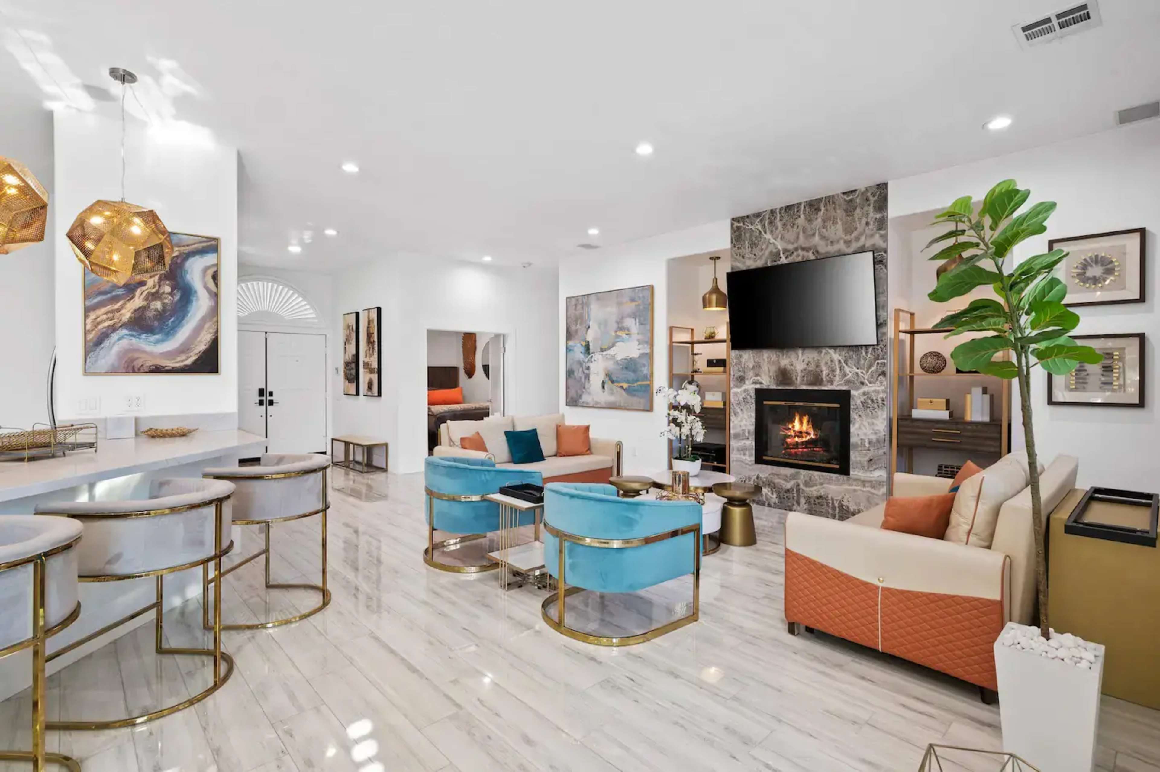 A modern living room with a fireplace, stylish seating arrangements, and contemporary artwork on the walls.