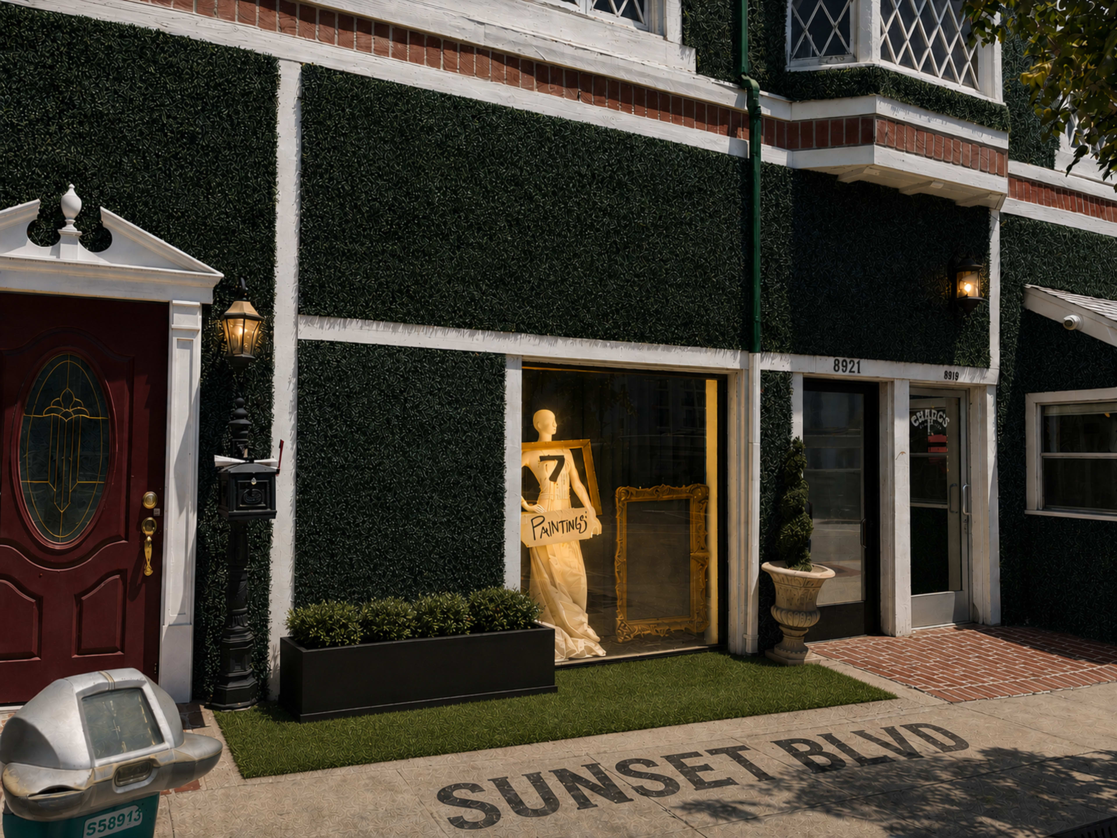 The image shows a storefront on Sunset Boulevard with a mannequin dressed in white, framed by a large golden picture frame inside.