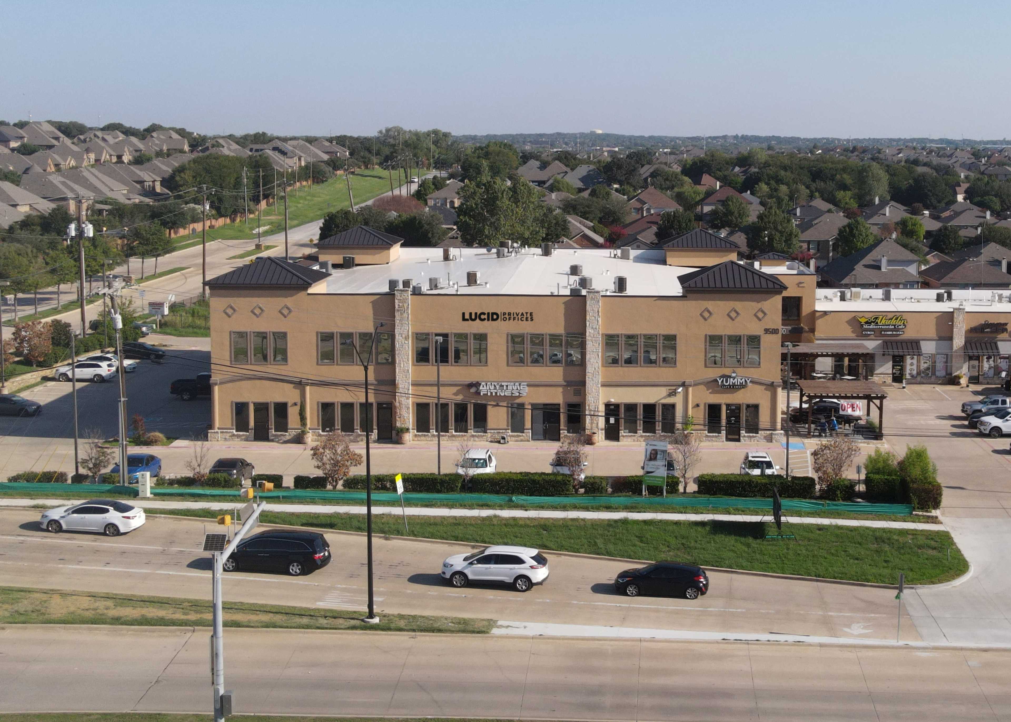 The image shows a two-story commercial building labeled "LUCID SMILE," surrounded by parked cars and residential areas in the background.