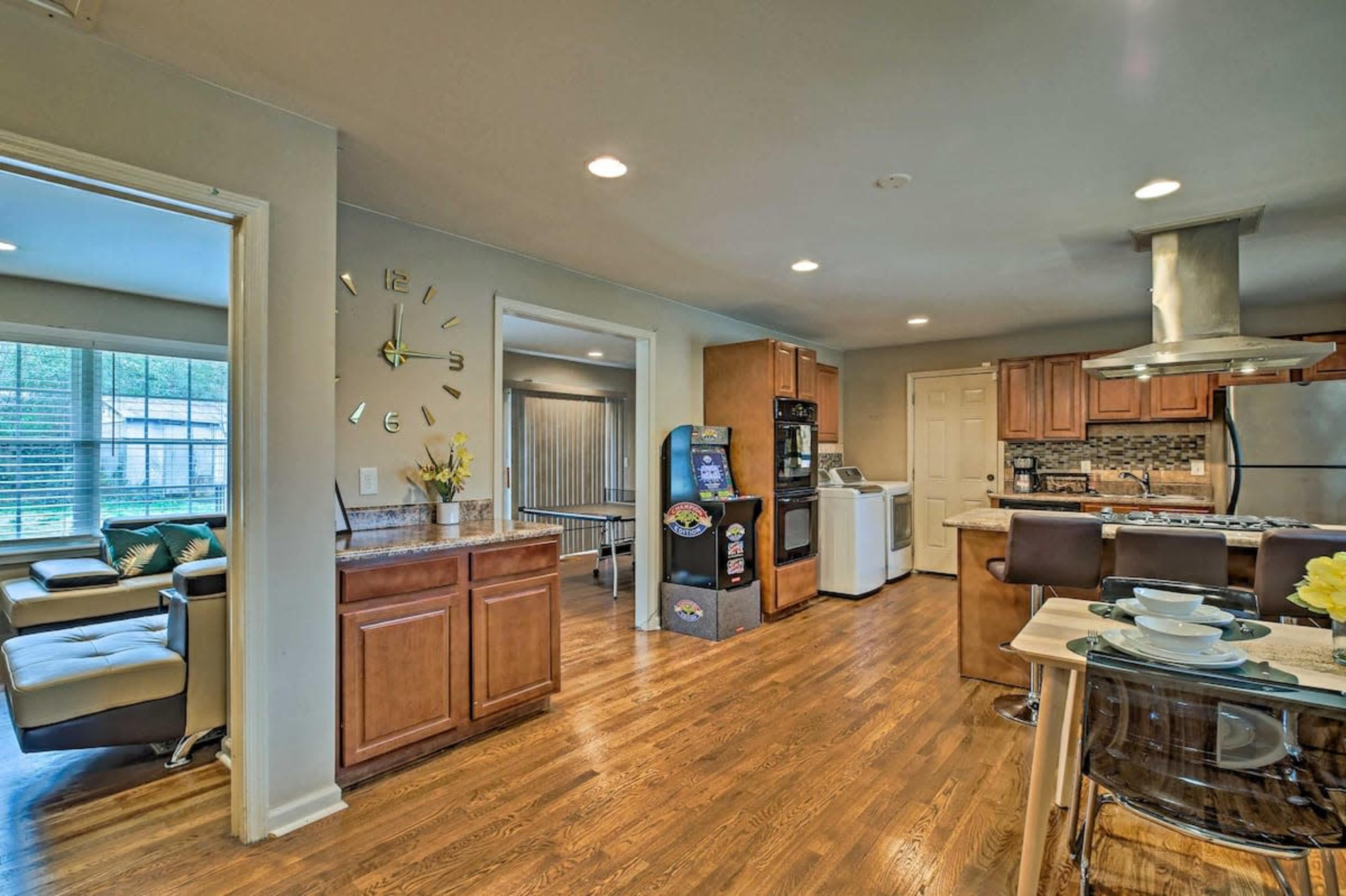 A modern kitchen and dining area featuring wooden cabinetry, a stainless steel refrigerator, a laundry area, and a small table set for dining.